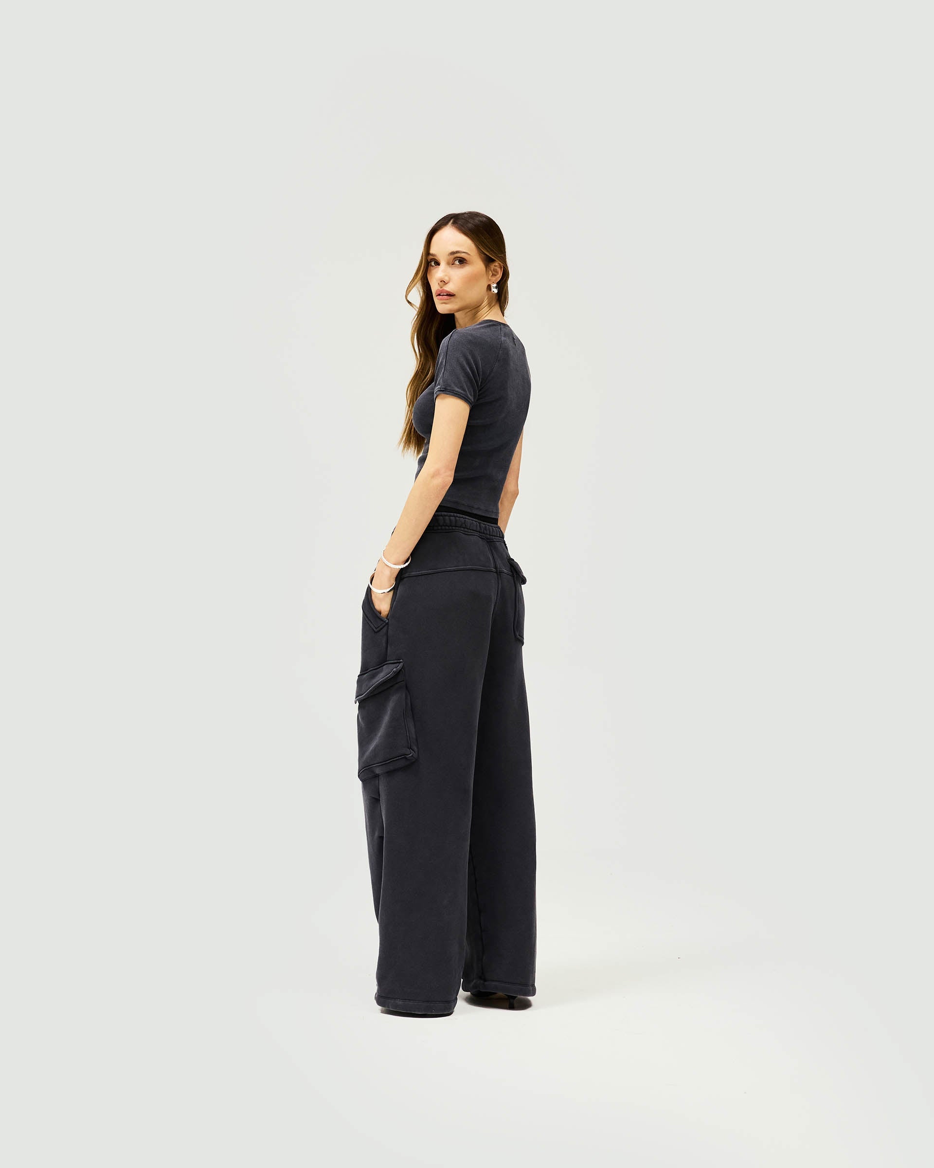 Woman wearing relaxed fit black cargo joggers on a plain white background | Initial Cargo Jogger in Washed Black | Heavyweight cotton bottoms with patch pockets | Womens Initial Bottoms | Represent Clo