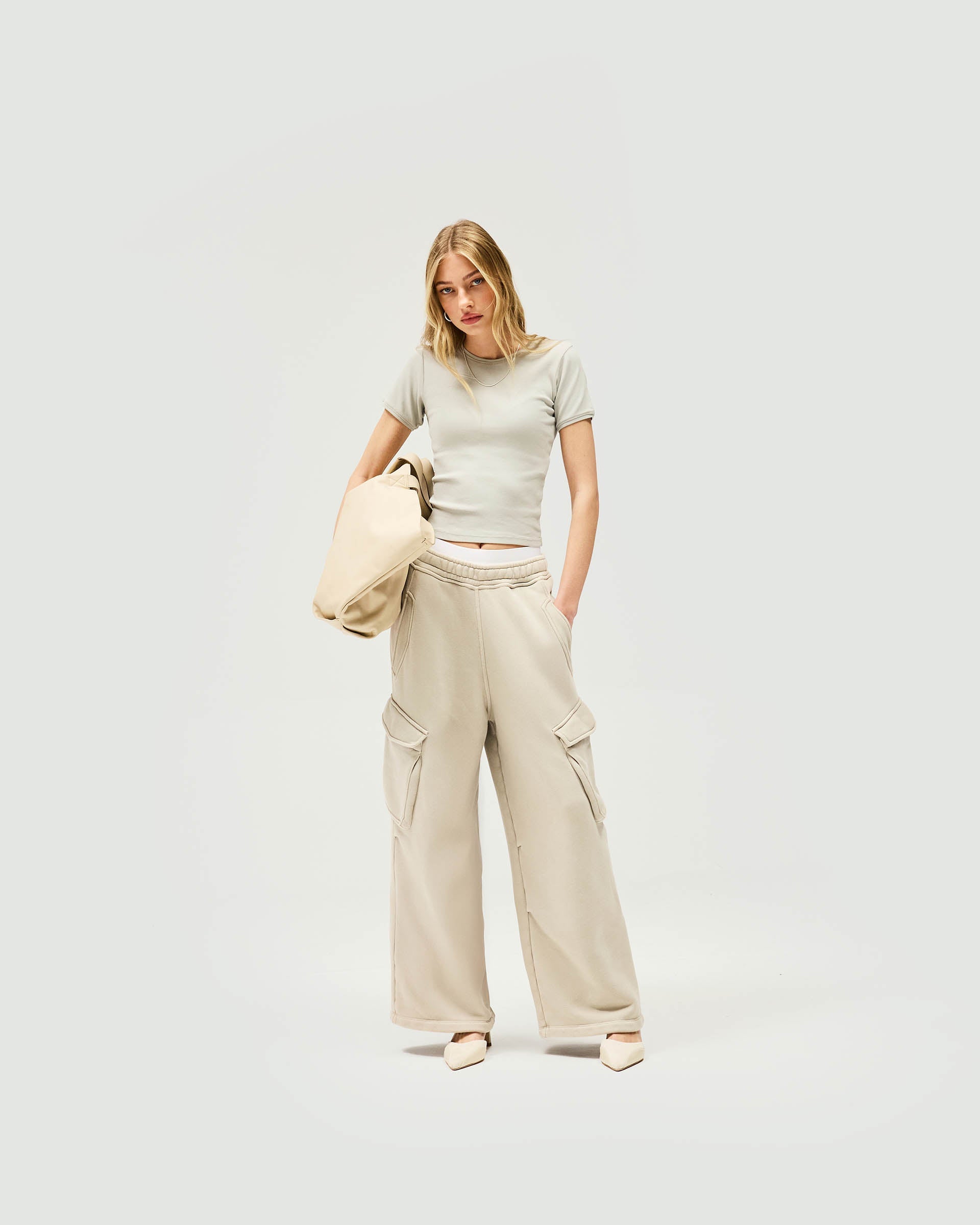 Woman wearing a grey cropped t-shirt on a plain white background | Initial Rib Baby T-Shirt in Storm | Cropped fit ribbed tops with high build embroidery | Womens Initial Tops | Represent Clo