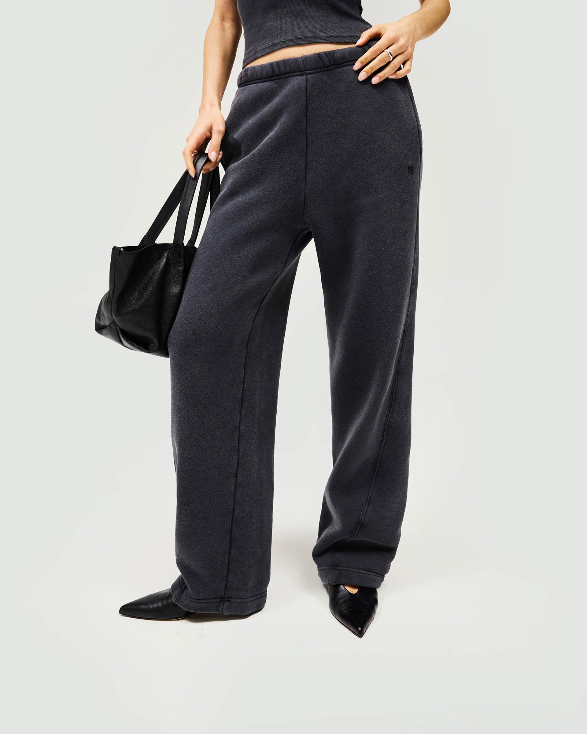 Woman wearing black joggers on a plain white background | Initial Twisted Seam Jogger in Washed Black | Joggers with twisted seams and elasticised waist | Womens Initial Bottoms | Represent Clo