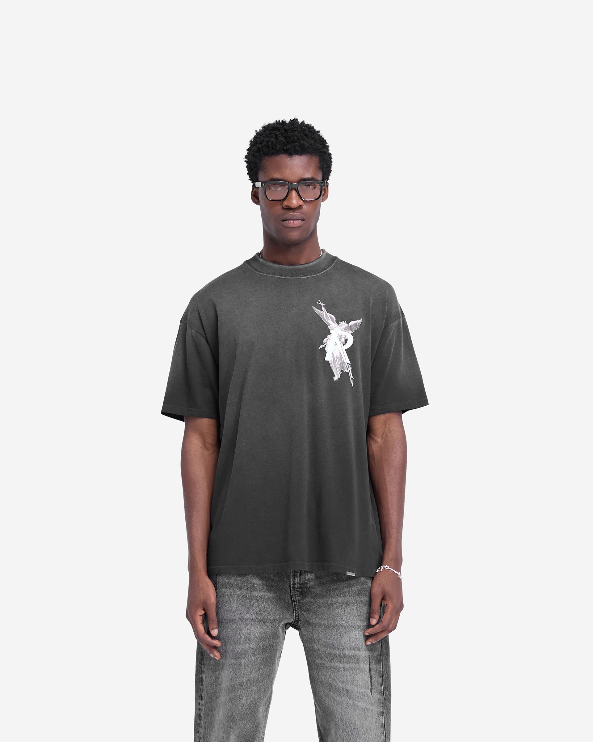 Man wearing a black t-shirt on a plain white background | Archangel T-Shirt in Stained Black | Slightly oversized t-shirt with high density graphic | FW24 T-Shirts | Represent Clo