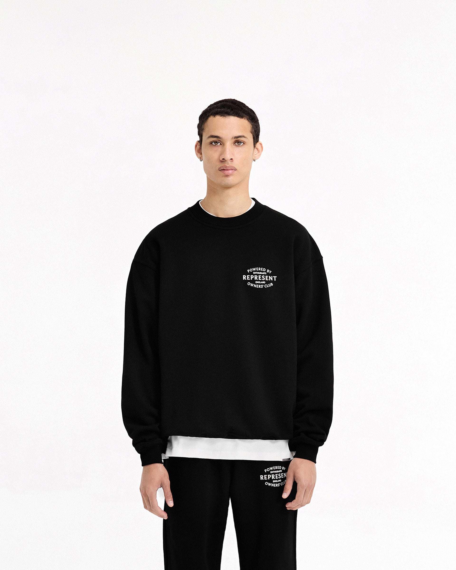 Man wearing a black sweater on a plain white background | Represent Owners Club Stamp Sweater in Jet Black | Oversized fit sweater with ribbed trims | Owners Club Sweaters | Represent Clo