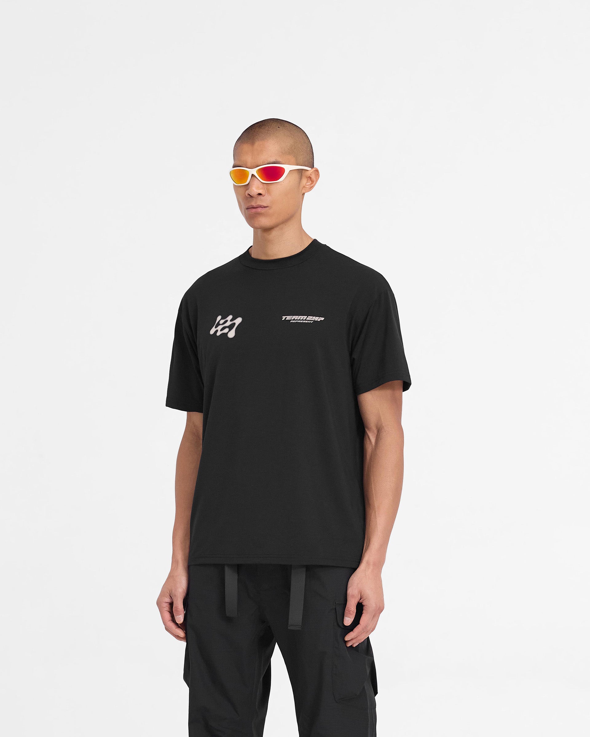 Man wearing a black oversized t-shirt on a plain white background | 247 Future Terrains Oversized T-Shirt in Black | Quick drying t-shirt with 4-way stretch | 247 T-Shirts | Represent Clo