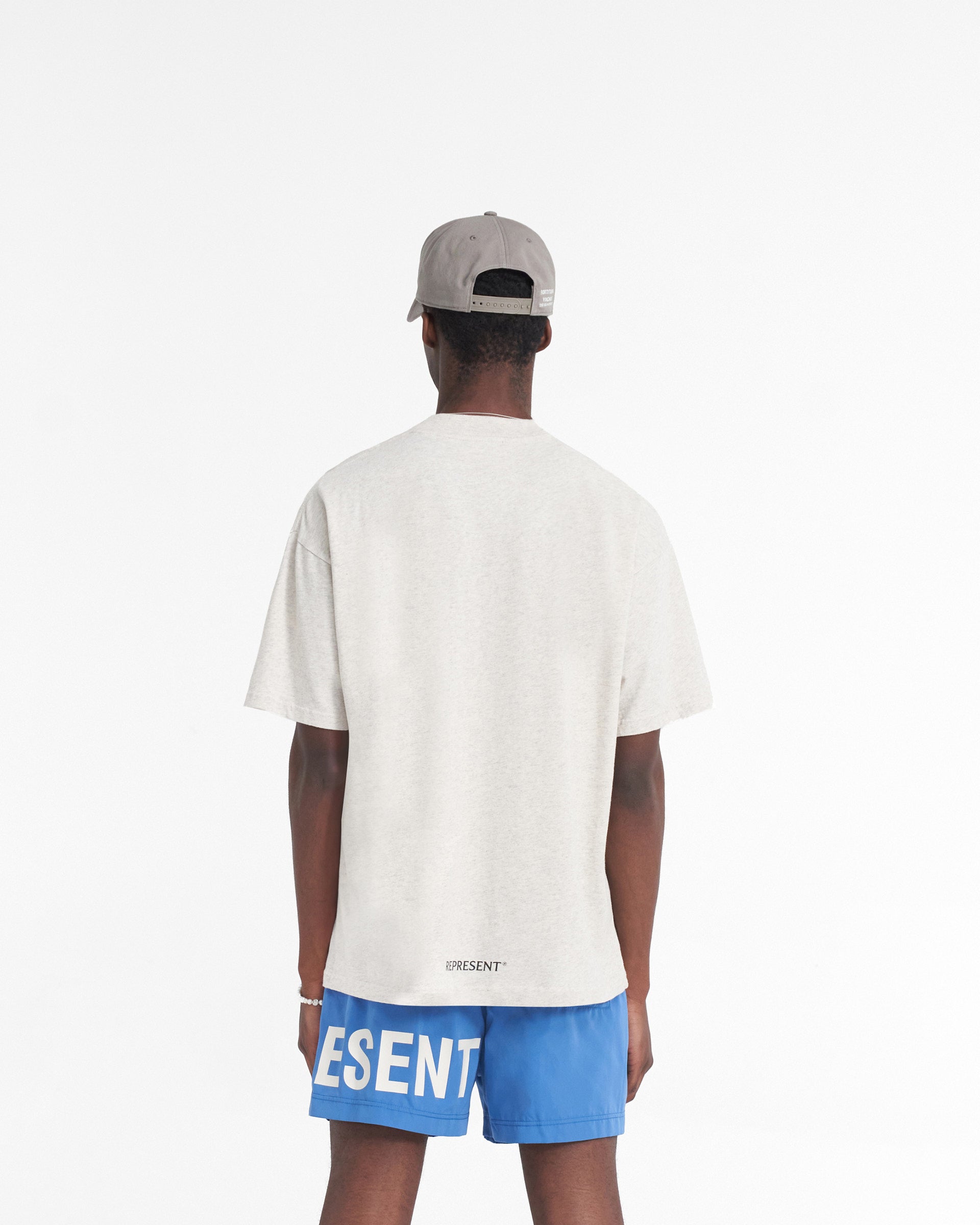 Man wearing a cream t-shirt on a plain white background | Higher Truth T-Shirt in Cream Marl | Oversized t-shirt with updated crewneck collar and Higher Truth graphic | SS24 T-Shirts | Represent Clo