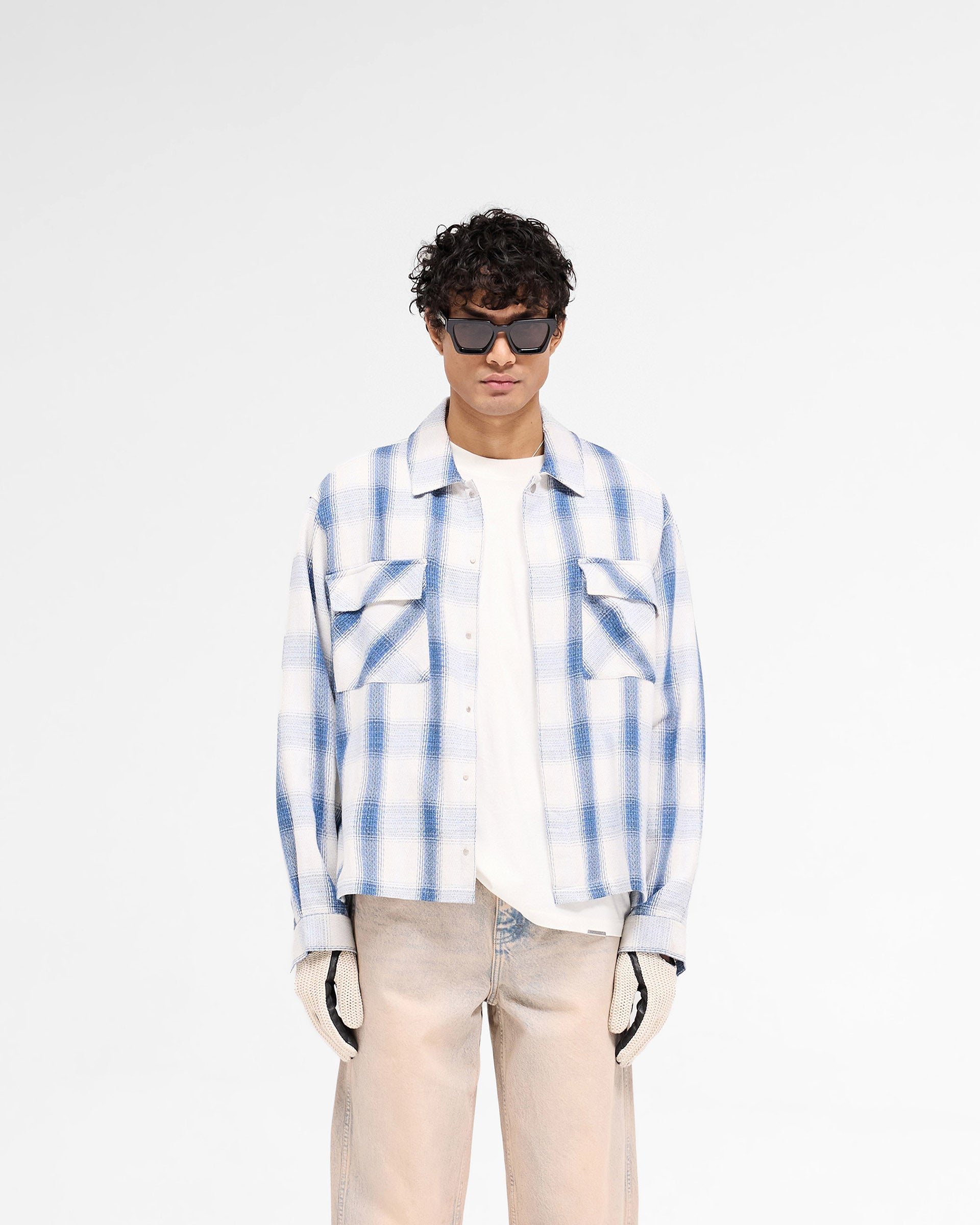 Man wearing a mid blue flannel shirt on a plain white background | Season Flannel Shirt in Mid Blue | Textured shirt with straight hem and front flap pockets | SS25 Shirts | Represent Clo