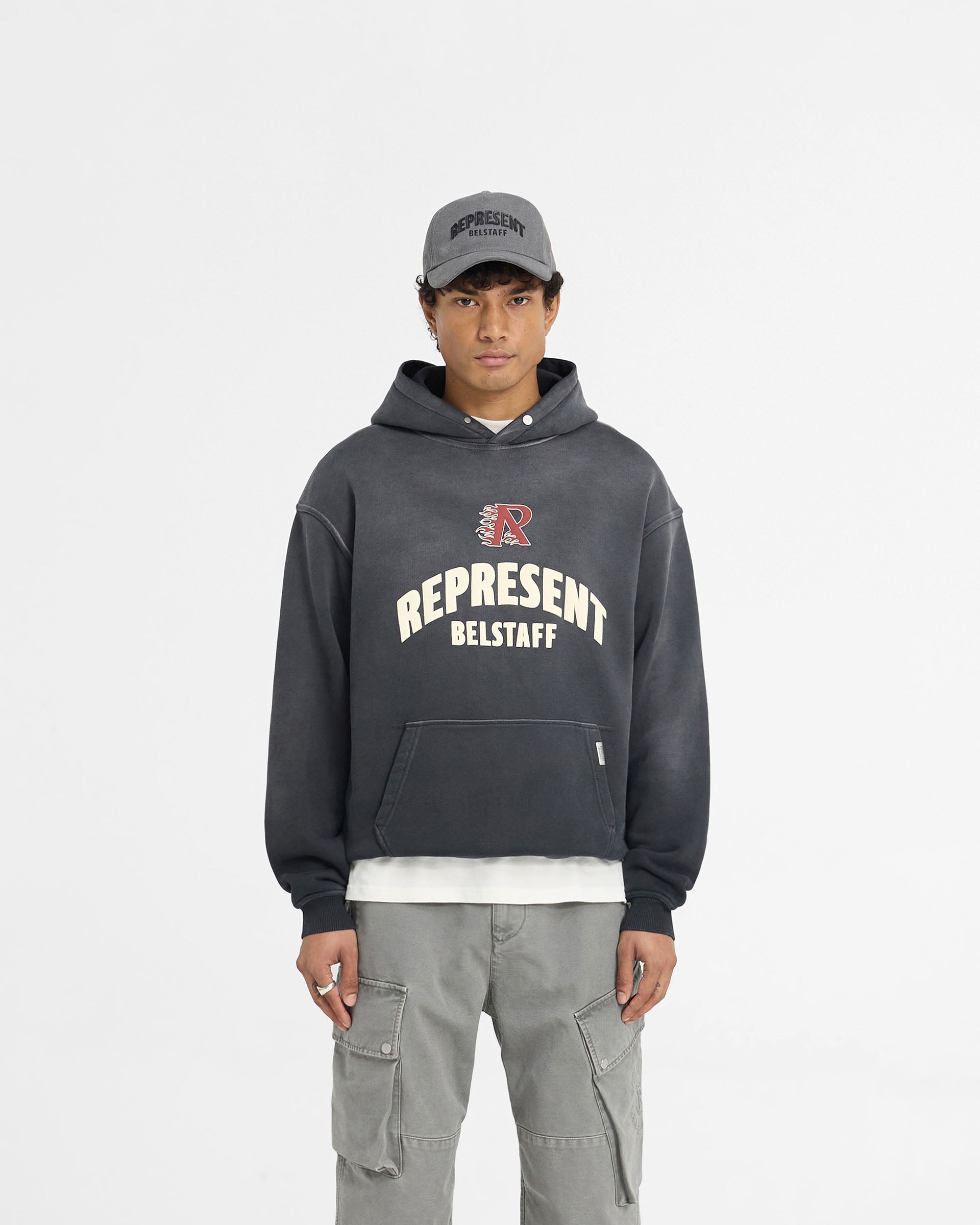 Man wearing an oversized black hoodie on a plain white background | Represent X Belstaff Flame Phoenix Hoodie in Shadow | Heavyweight hoodie with stylised logos | Exclusives Hoodies | Represent Clo