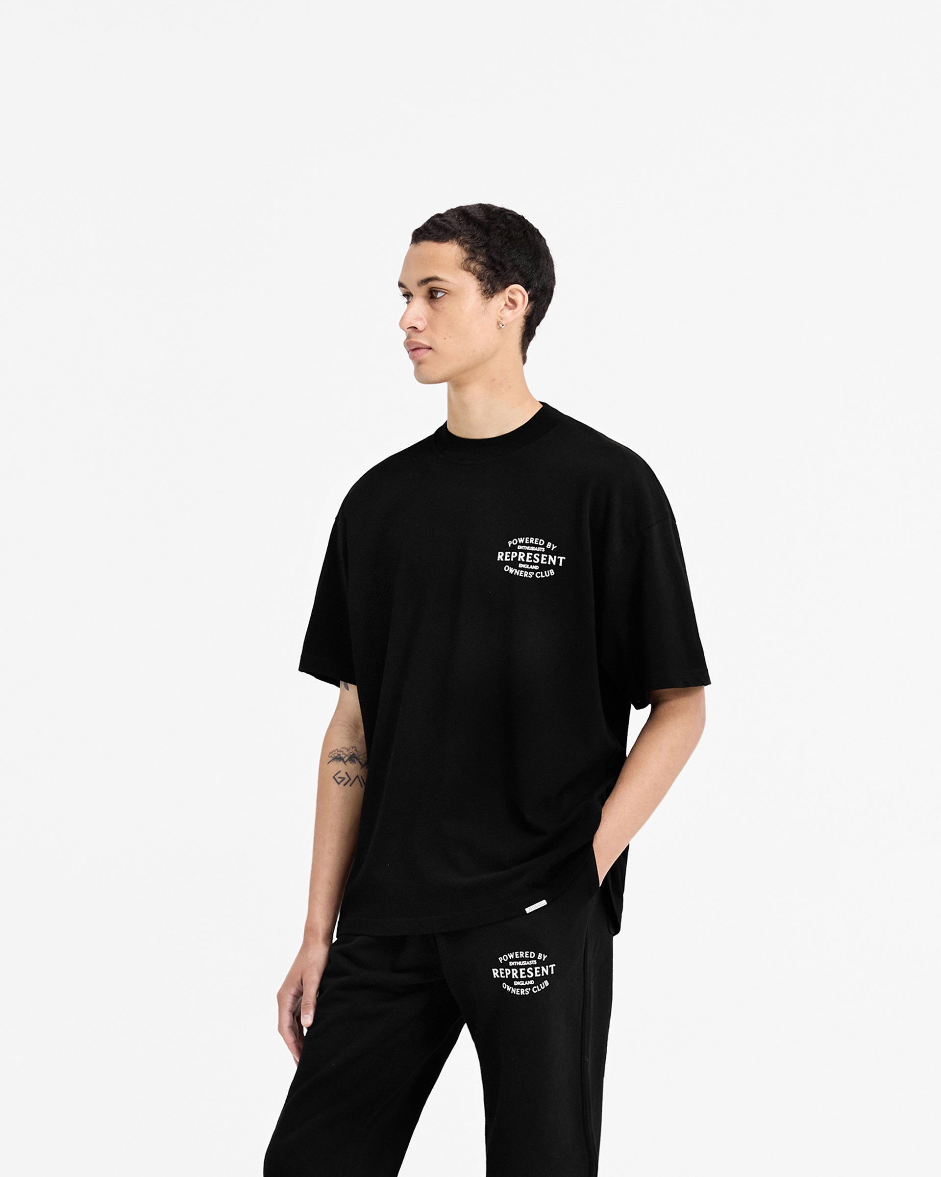 Man wearing a black t-shirt on a plain white background | Represent Owners Club Stamp T-Shirt in Jet Black | Oversized fit with high build branding | Owners Club T-Shirts | Represent Clo