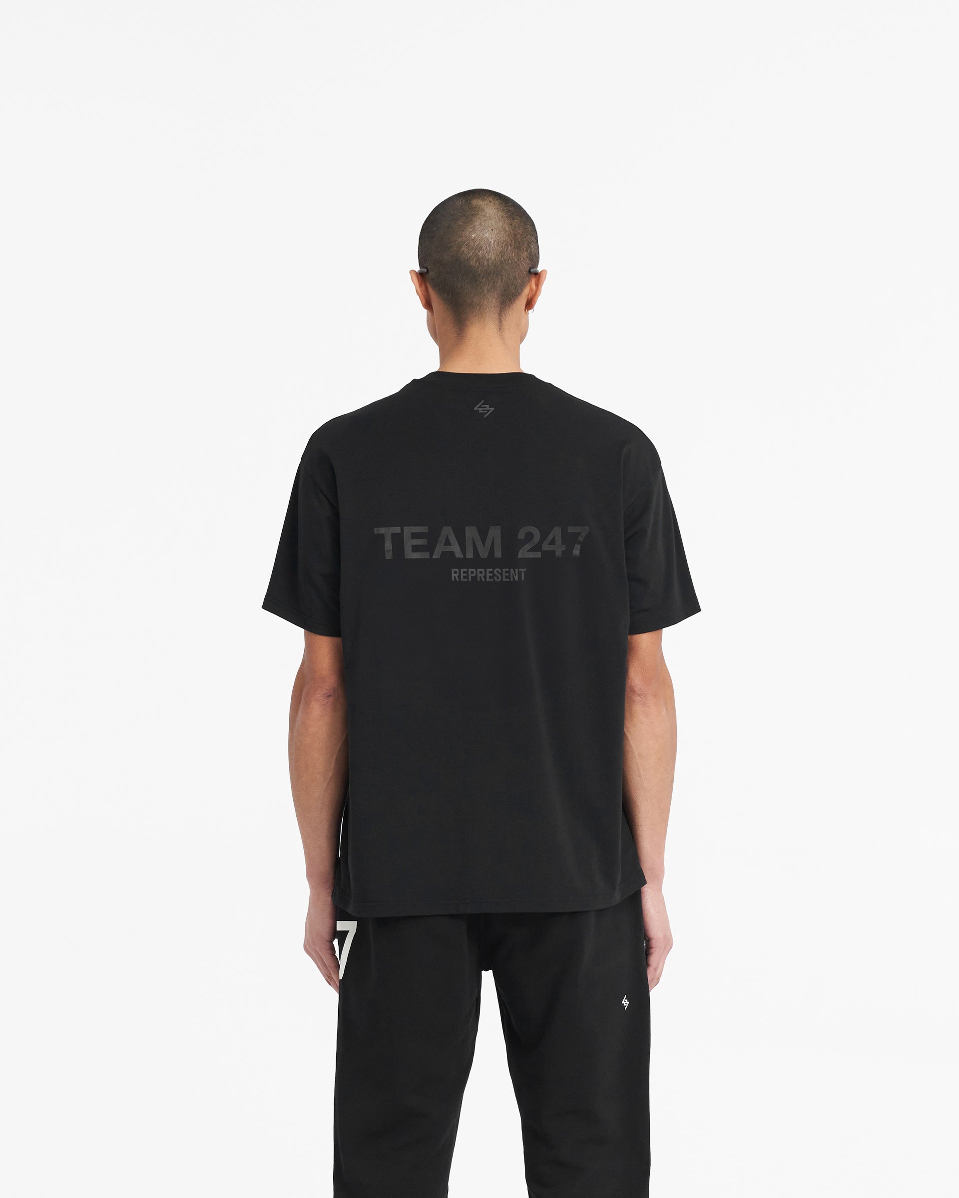Man wearing an oversized black t-shirt on a plain white background | Team 247 Oversized T-Shirt in Matte Black | Gym top with quick dry and antibacterial features | 247 T-Shirts | Represent Clo