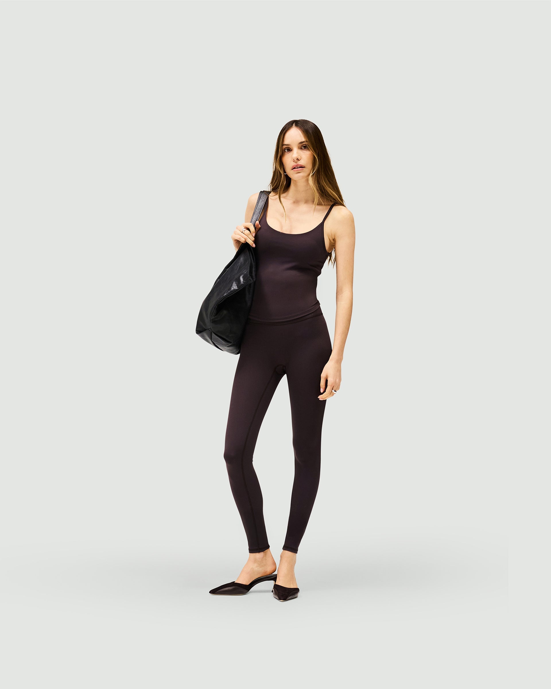 Woman wearing black leggings on a plain white background | Owners Club Legging in Black Coffee | Seamless front leggings with sculpting back | Womens Owners Club Bottoms | Represent Clo