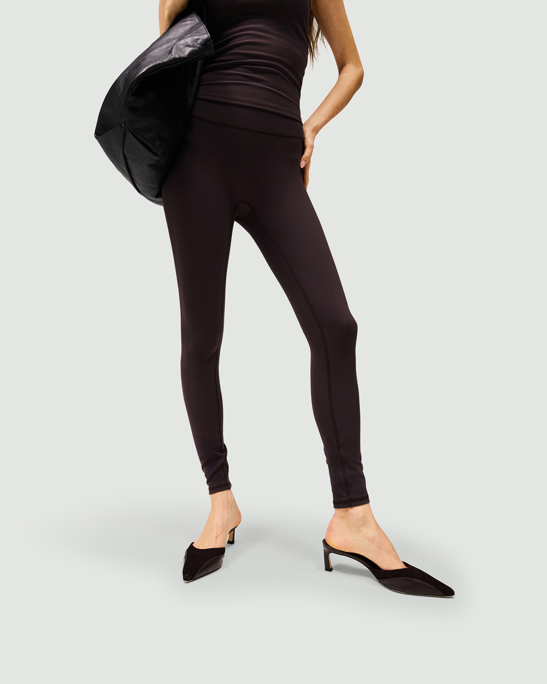 Woman wearing black leggings on a plain white background | Owners Club Legging in Black Coffee | Leggings with no front seams and sculpting back | Womens Owners Club Bottoms | Represent Clo