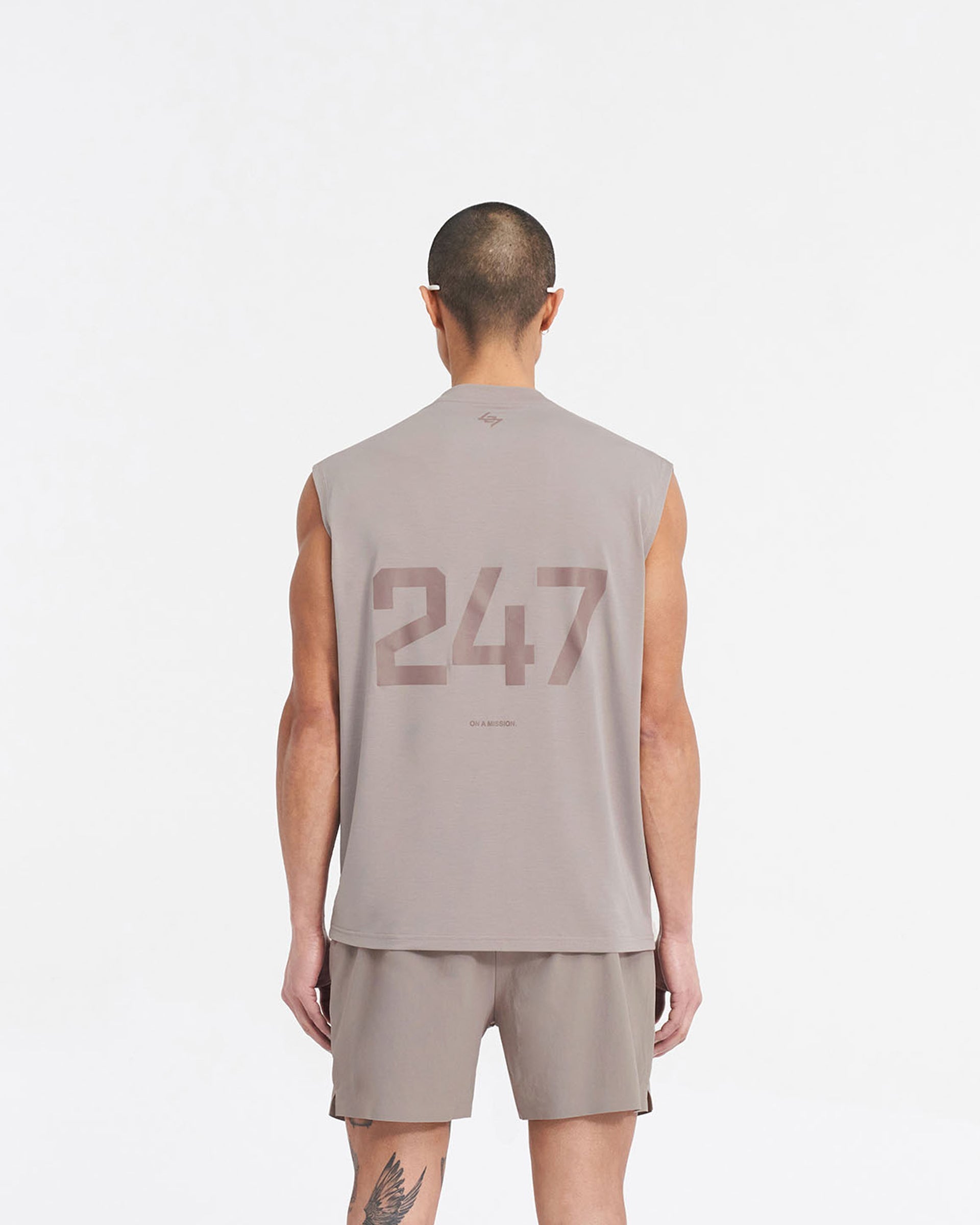 Man wearing an oversized grey tank top on a plain white background | 247 Oversized Tank in Cinder | Lightweight tank with breathable 4-way stretch fabric | 247 T-Shirts | Represent Clo