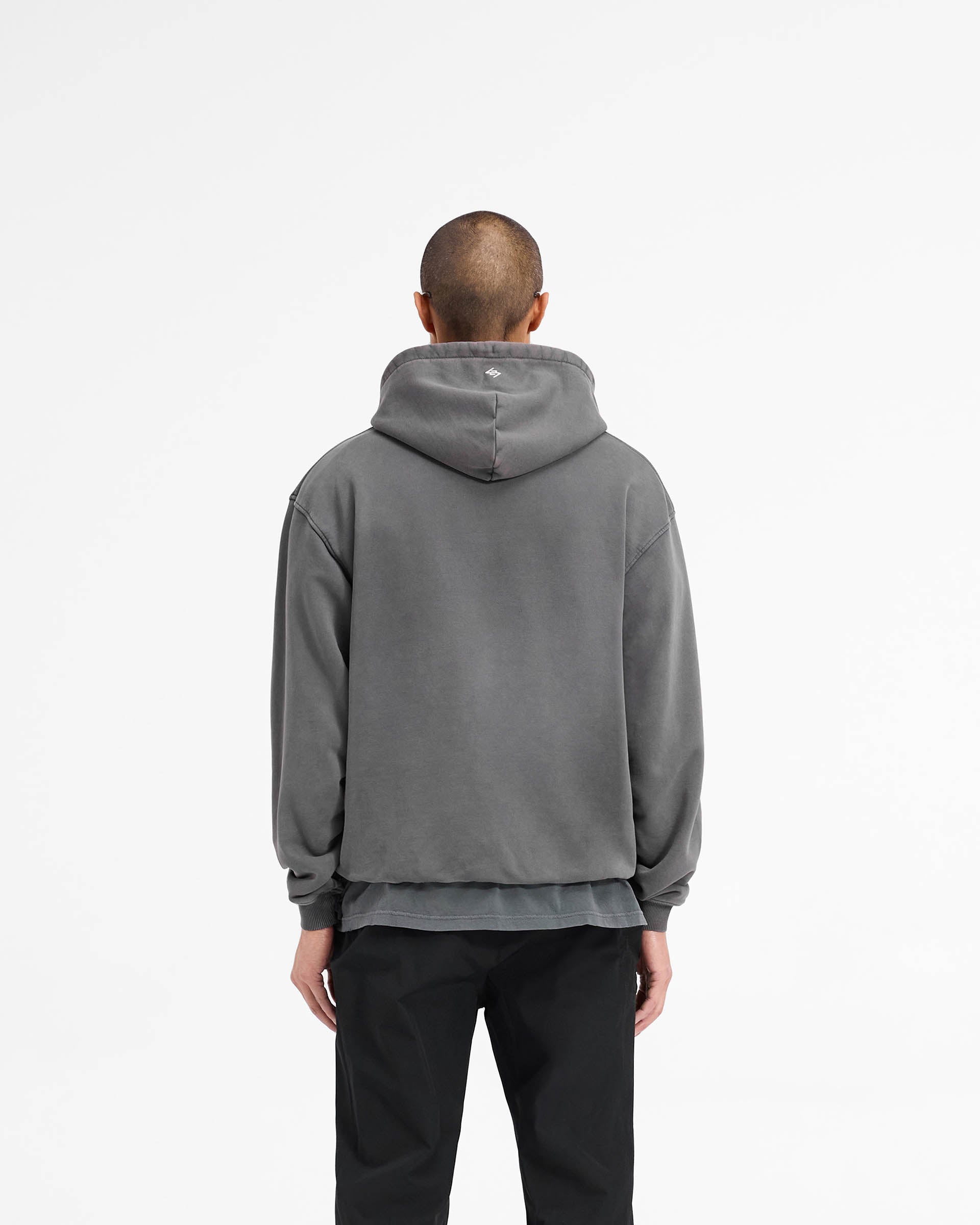 Man wearing a black hoodie on a plain white background | 247 On A Mission Hoodie in Aged Black | Slightly oversized hoodie with embroidery and ribbed trims | 247 Hoodies | Represent Clo