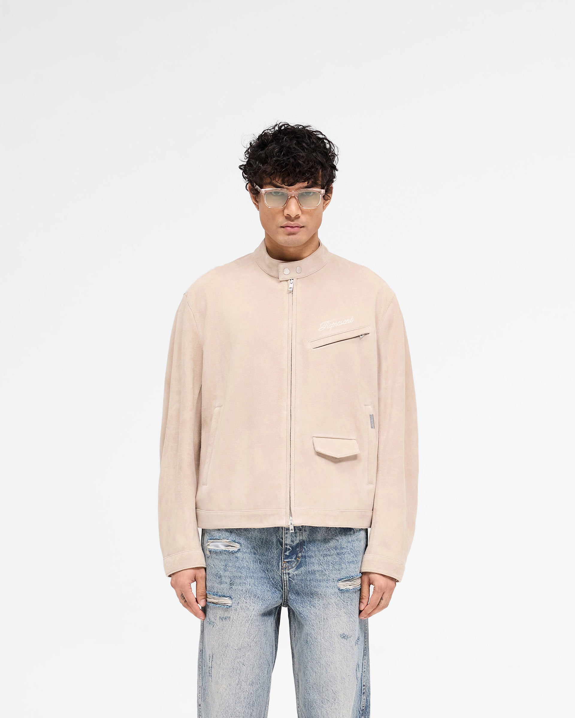 Man wearing a beige suede jacket on a plain white background | Overdrive Suede Jacket in Beige | Suede biker jacket with vented shoulders | SS25 Outerwear | Represent Clo