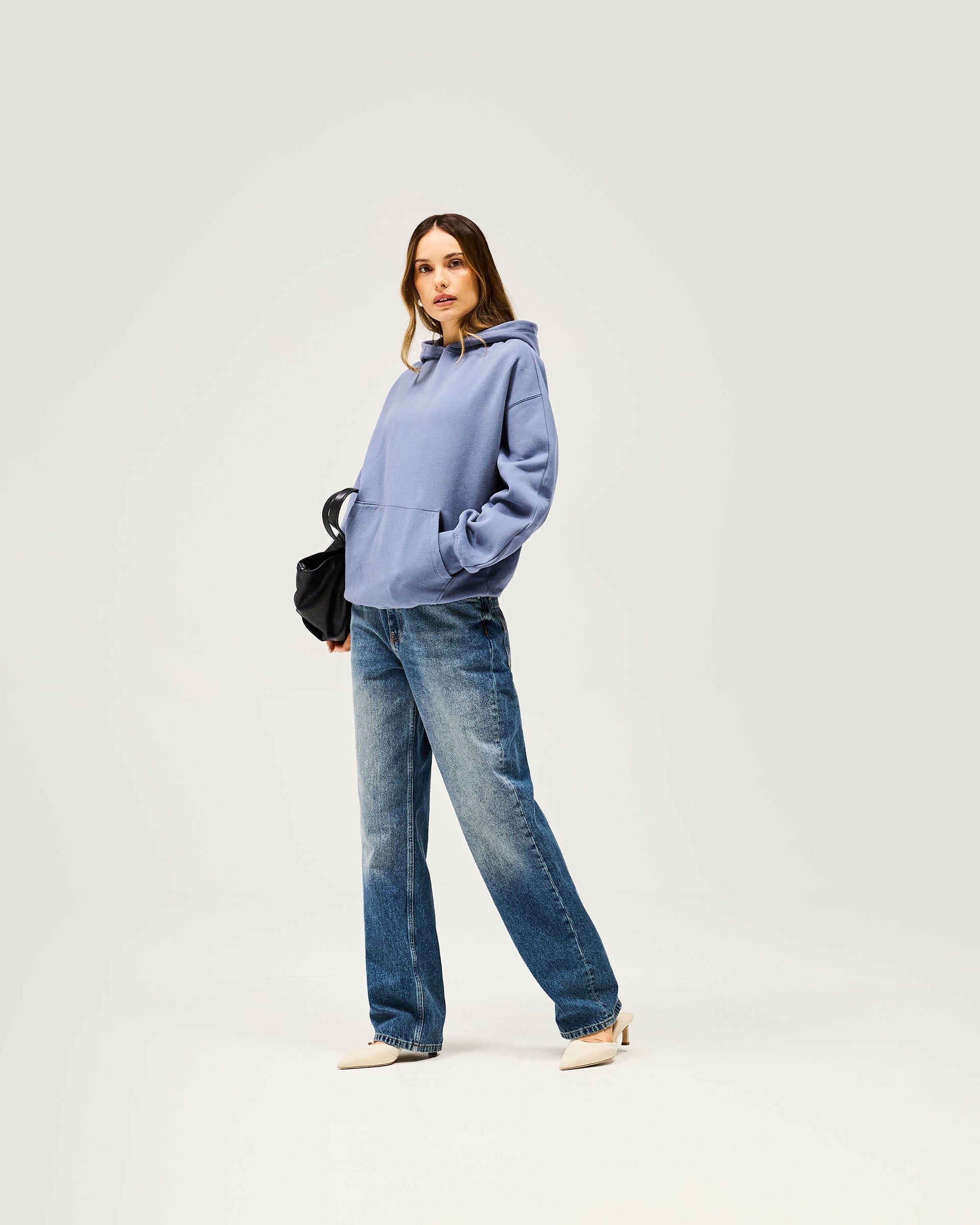 Woman wearing an oversized blue hoodie on a plain white background | Owners Club Boyfriend Hoodie in Steel Blue | Mid weight relaxed fit oversized hoodie | Womens Owners Club Hoodies | Represent Clo
