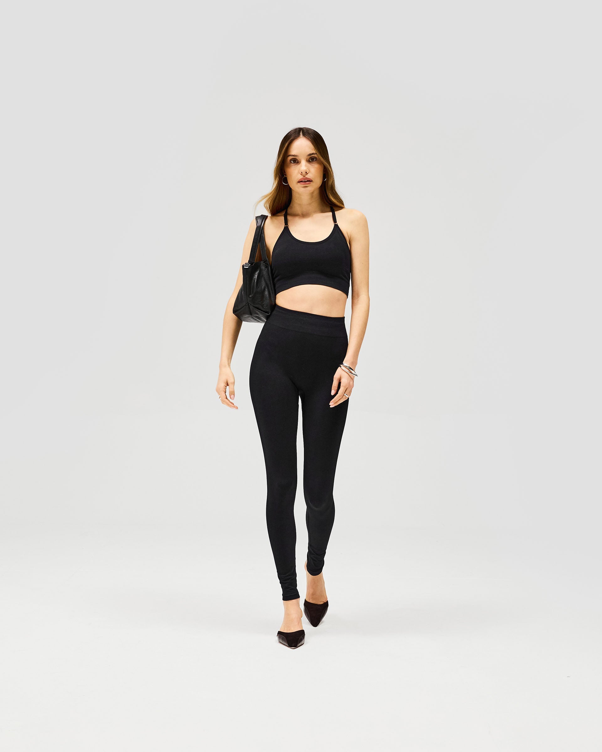 Woman wearing black seamless leggings on a plain white background | Owners Club Contour Seamless Legging in Jet Black | High waisted sculpted leggings | Womens Owners Club Bottoms | Represent Clo