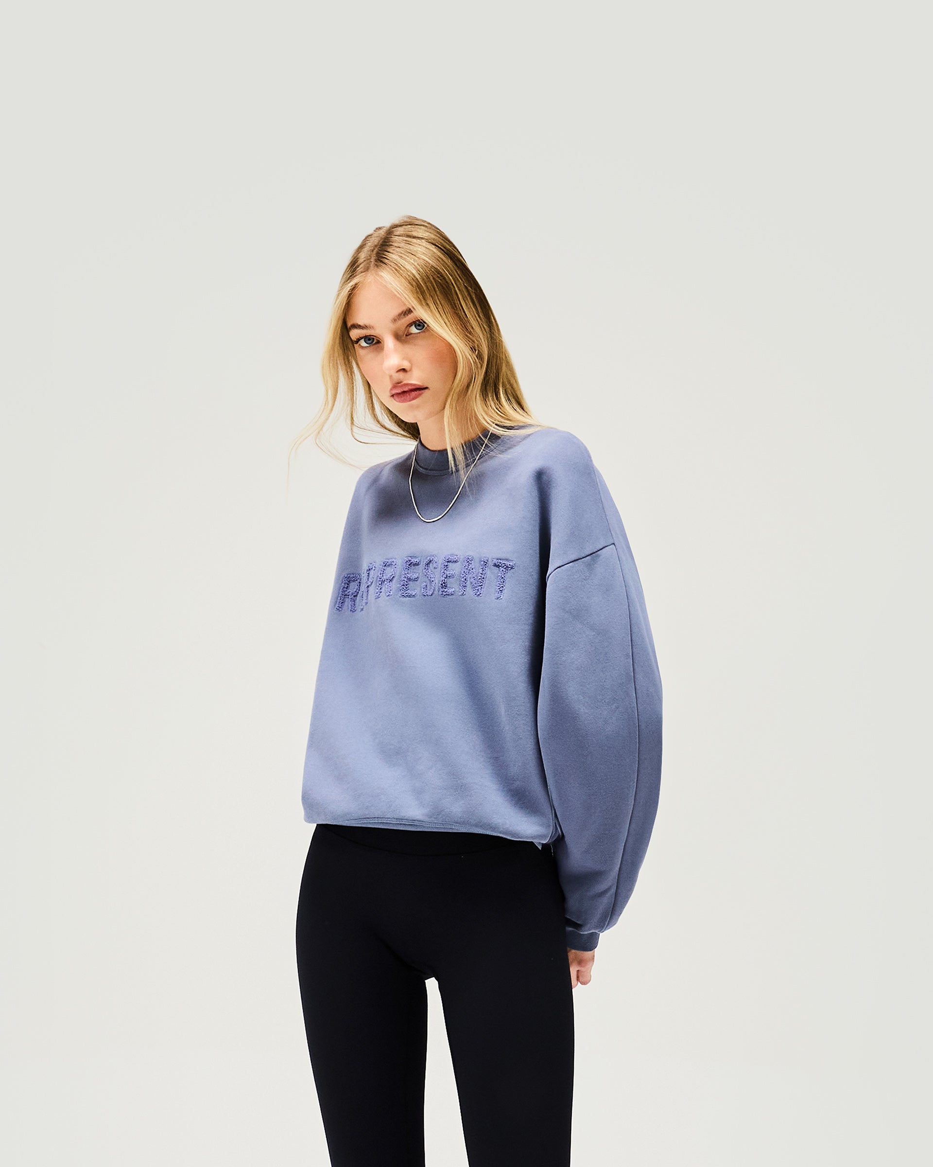 Back product image of a womens blue sweater on a plain white background | Owners Club Sweater in Steel Blue | Sweater with ribbed hem and tufted embroidery | Womens Owners Club Sweaters | Represent Clo