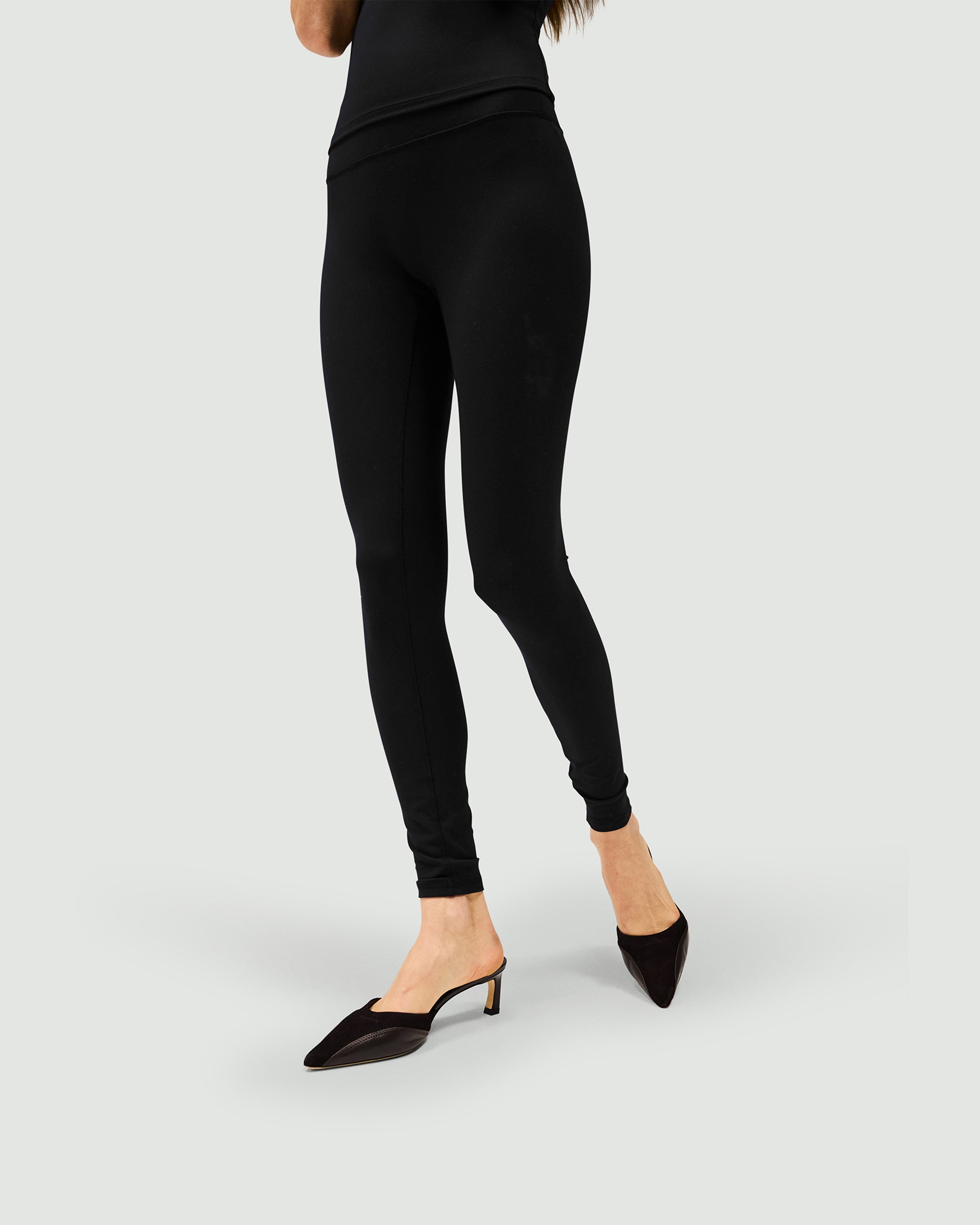 Woman wearing black leggings on a plain white background | Owners Club Legging in Jet Black | Sculpting leggings with no front seams | Womens Owners Club Bottoms | Represent Clo