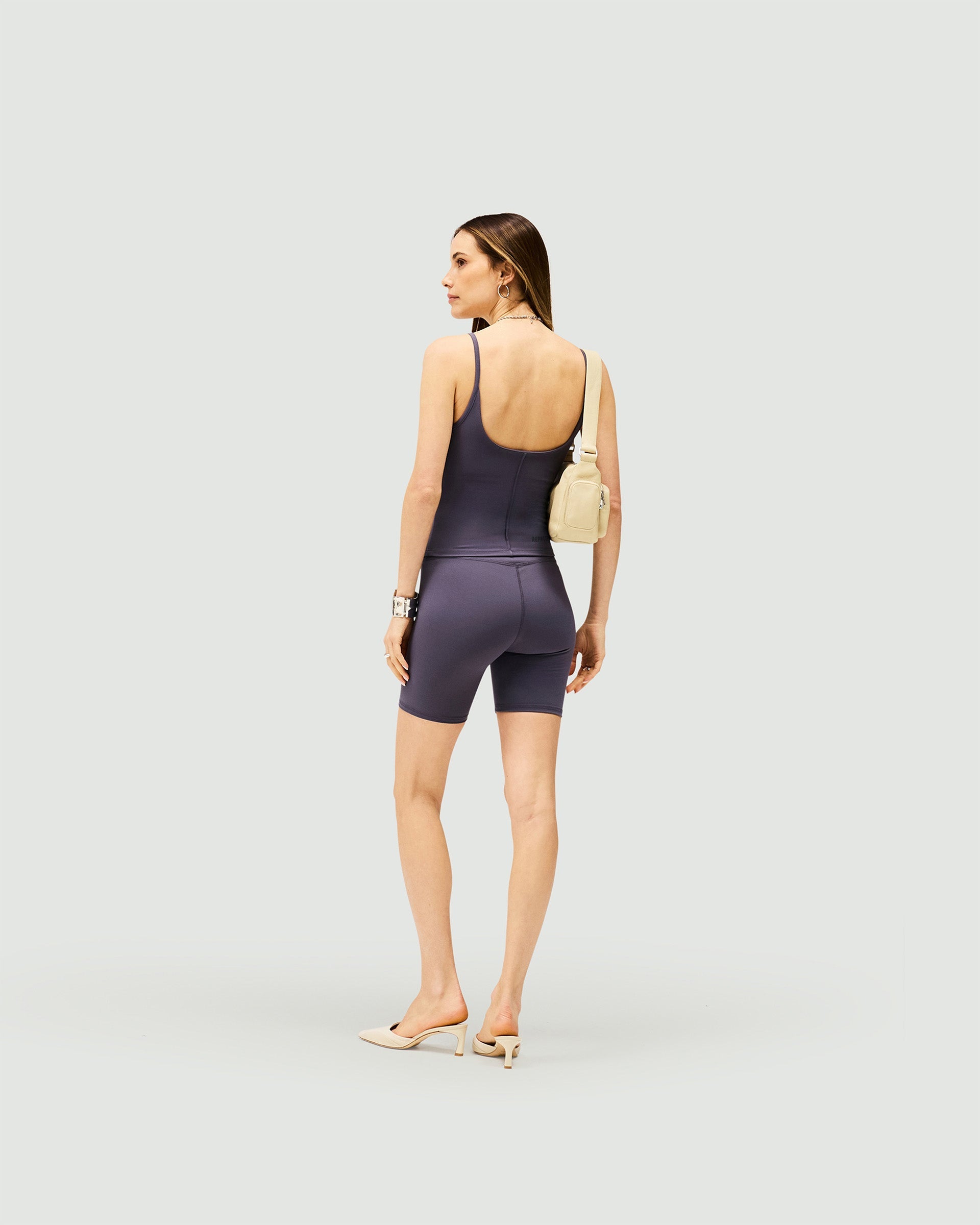 Woman wearing grey longerline bike shorts on a plain white background | Owners Club Longerline Bike Short in Grey | Bike shorts with sculpting detail and 4 way stretch | Womens Shorts | Represent Clo