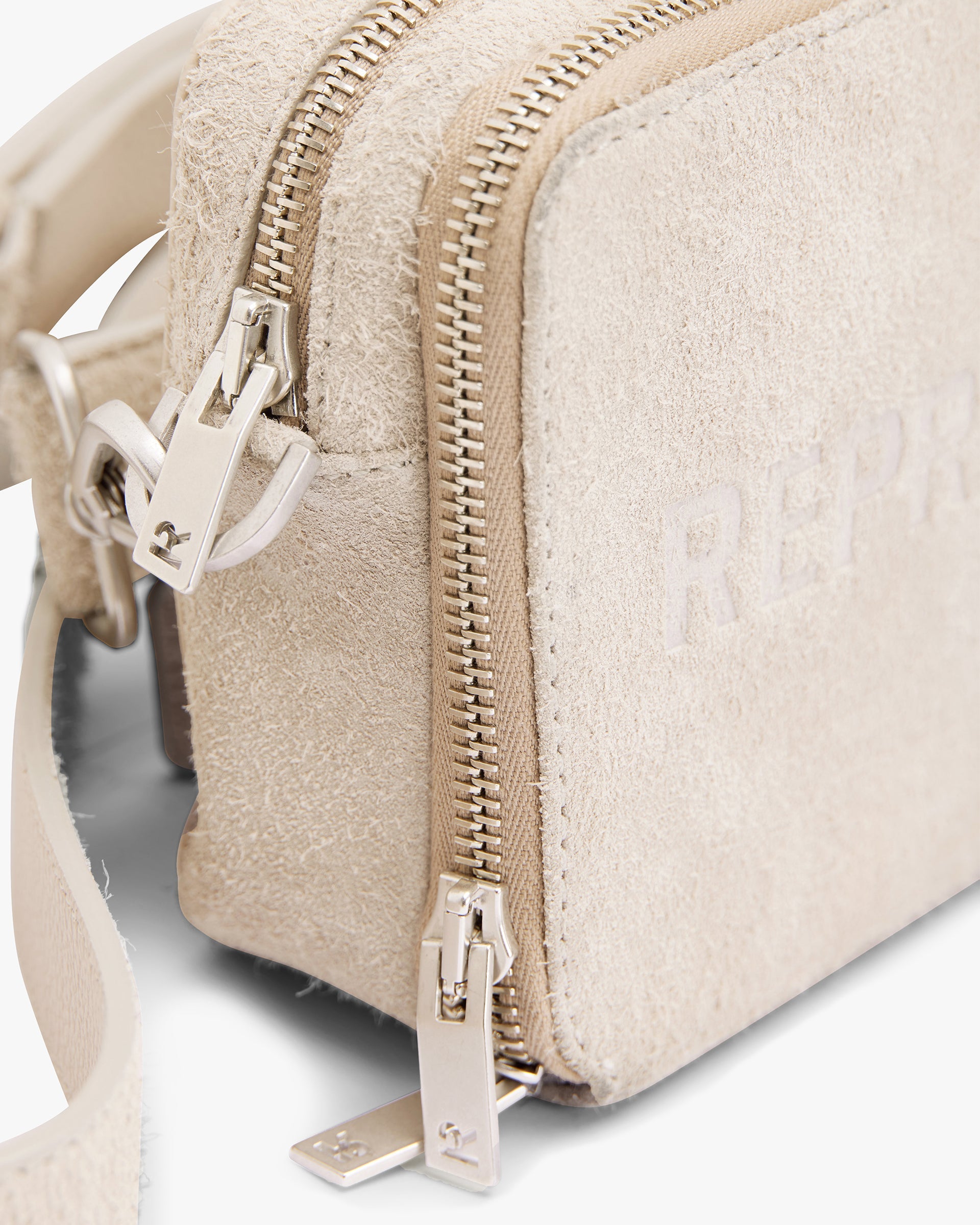 Close-up of cashmere camera bag on a plain white background | Represent Hairy Suede Camera Bag in Cashmere | Suede bag with adjustable strap and slip pockets | SS24 Accessories | Represent Clo