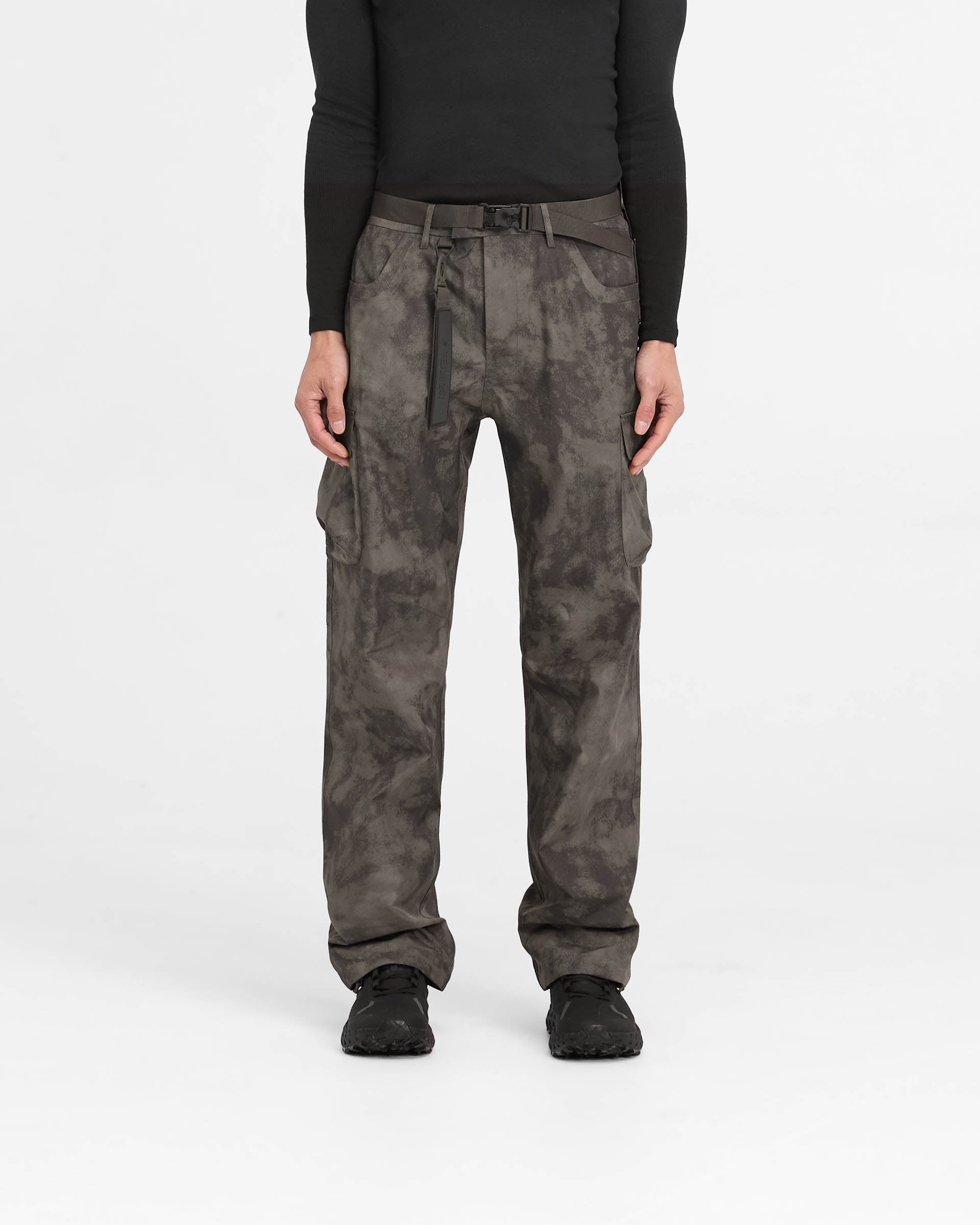 Man wearing straight leg green cargo pants on a plain white background | 247 Technical Cargo Pant in Terrain | Waterproof tech cargos with maglock buckle and bungee cord hem | 247 Pants | Represent Clo