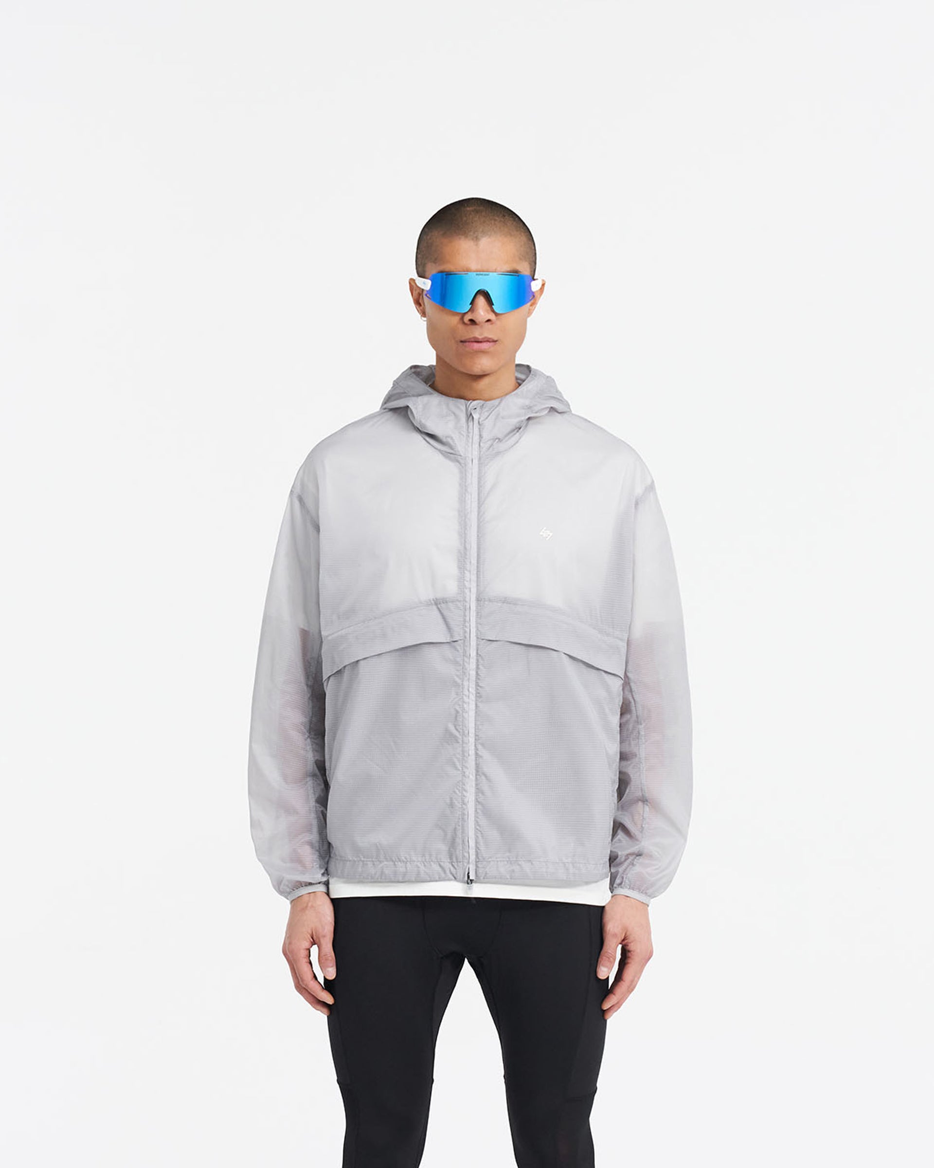 Man wearing a moonstone hooded training jacket on a plain white background | 247 Hooded Training Jacket in Moonstone | Translucent nylon ripstop outerwear with DWR coating | 247 Outerwear | Represent Clo