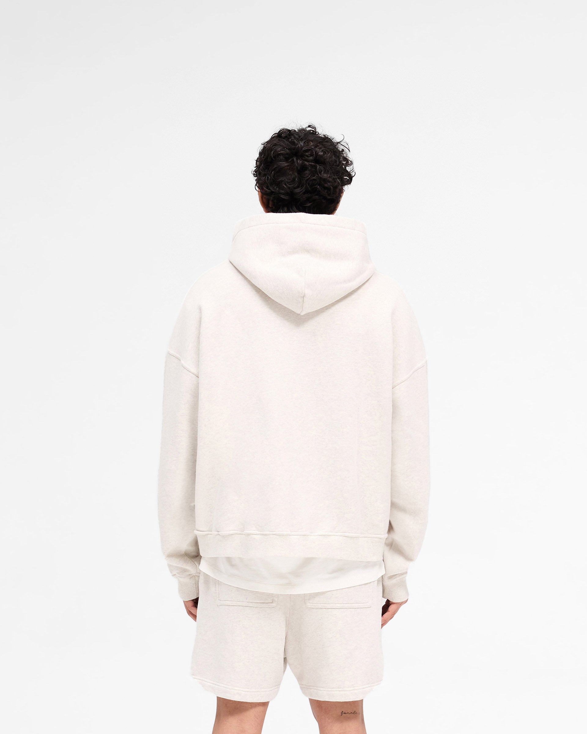 Man wearing a cream hoodie on a plain white background | Rep Applique Hoodie in Cream Marl | Boxy fit hoodies with textured applique | SS25 Hoodies | Represent Clo