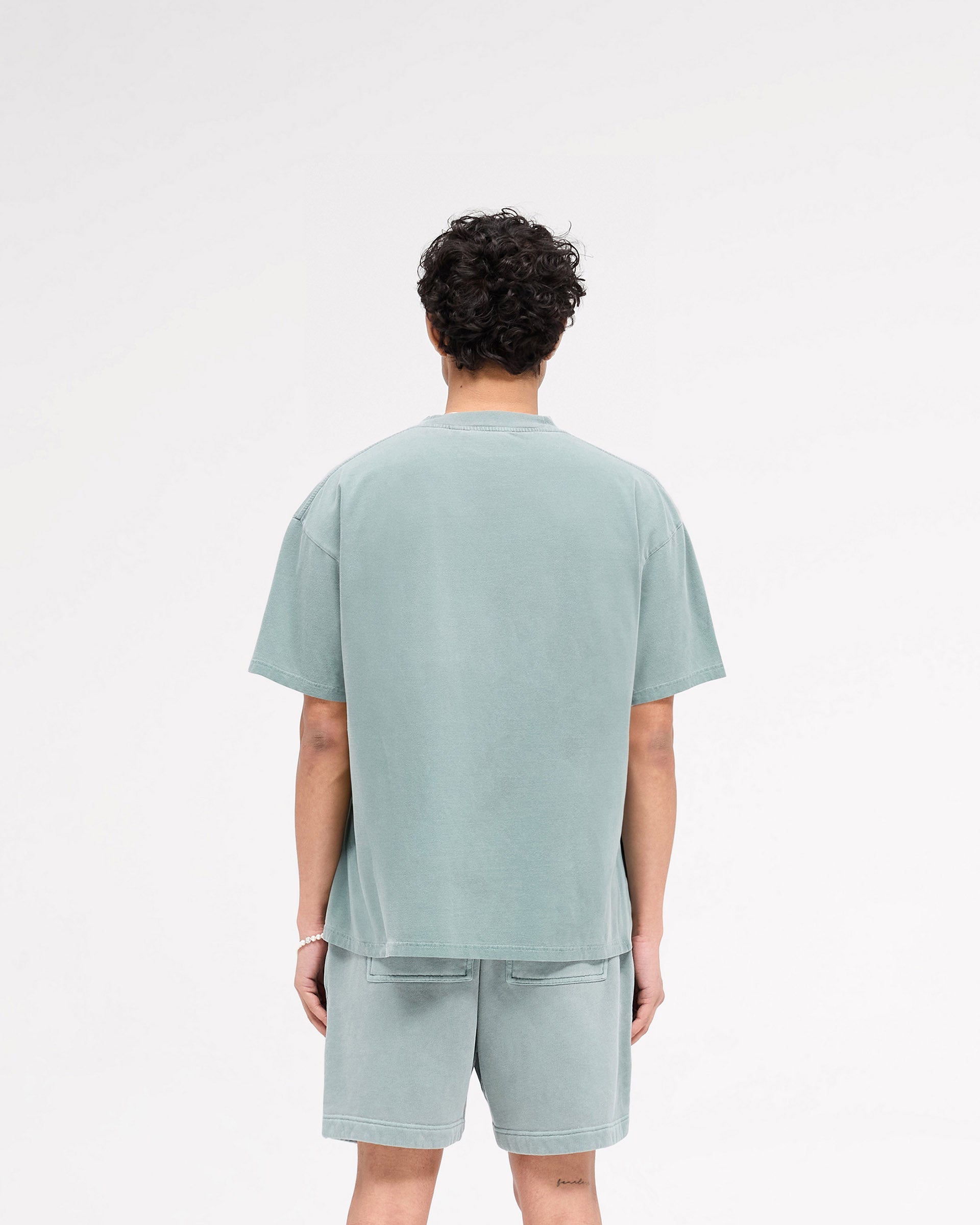 Man wearing a forest green t-shirt on a plain white background | Rep Applique T-Shirt in Forest Green | T-shirt with textured Rep applique and oversized fit | SS25 T-Shirts | Represent Clo