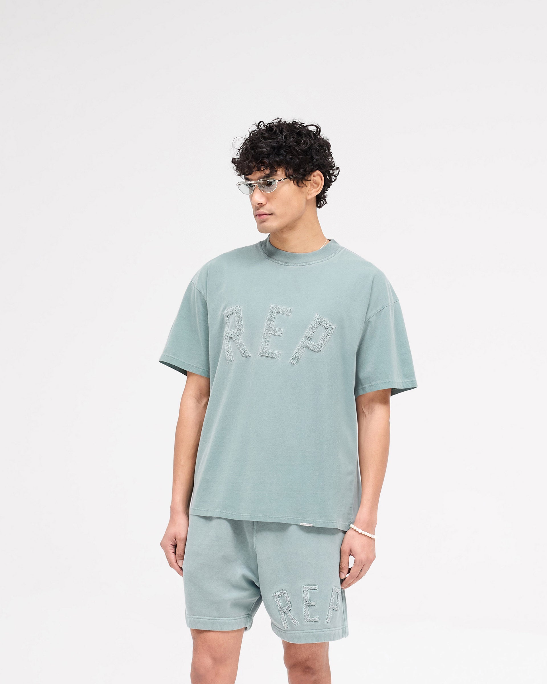 Back product image of a mens green t-shirt on a plain white background | Rep Applique T-Shirt in Forest Green | Medium weight t-shirt with overlock seams | SS25 T-Shirts | Represent Clo