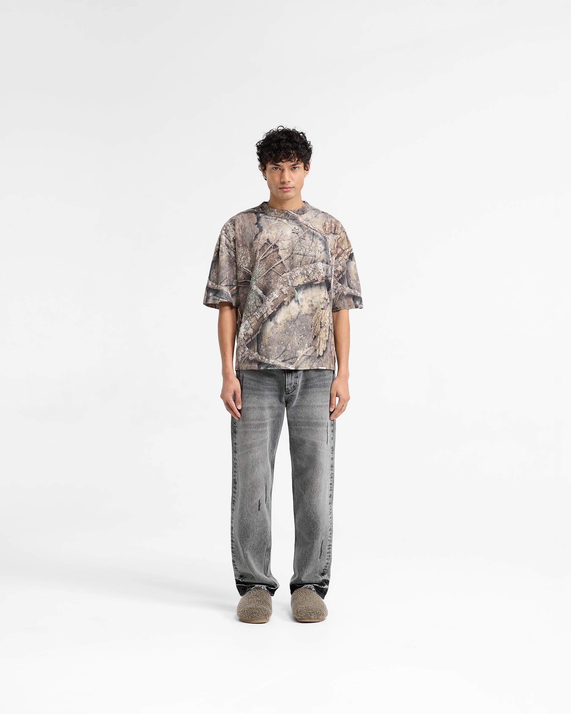 Man wearing a camo t-shirt on a plain white background | Realtree Camo T-Shirt in Camo | Oversized boxy fit with dropped shoulders | SS25 T-Shirts | Represent Clo
