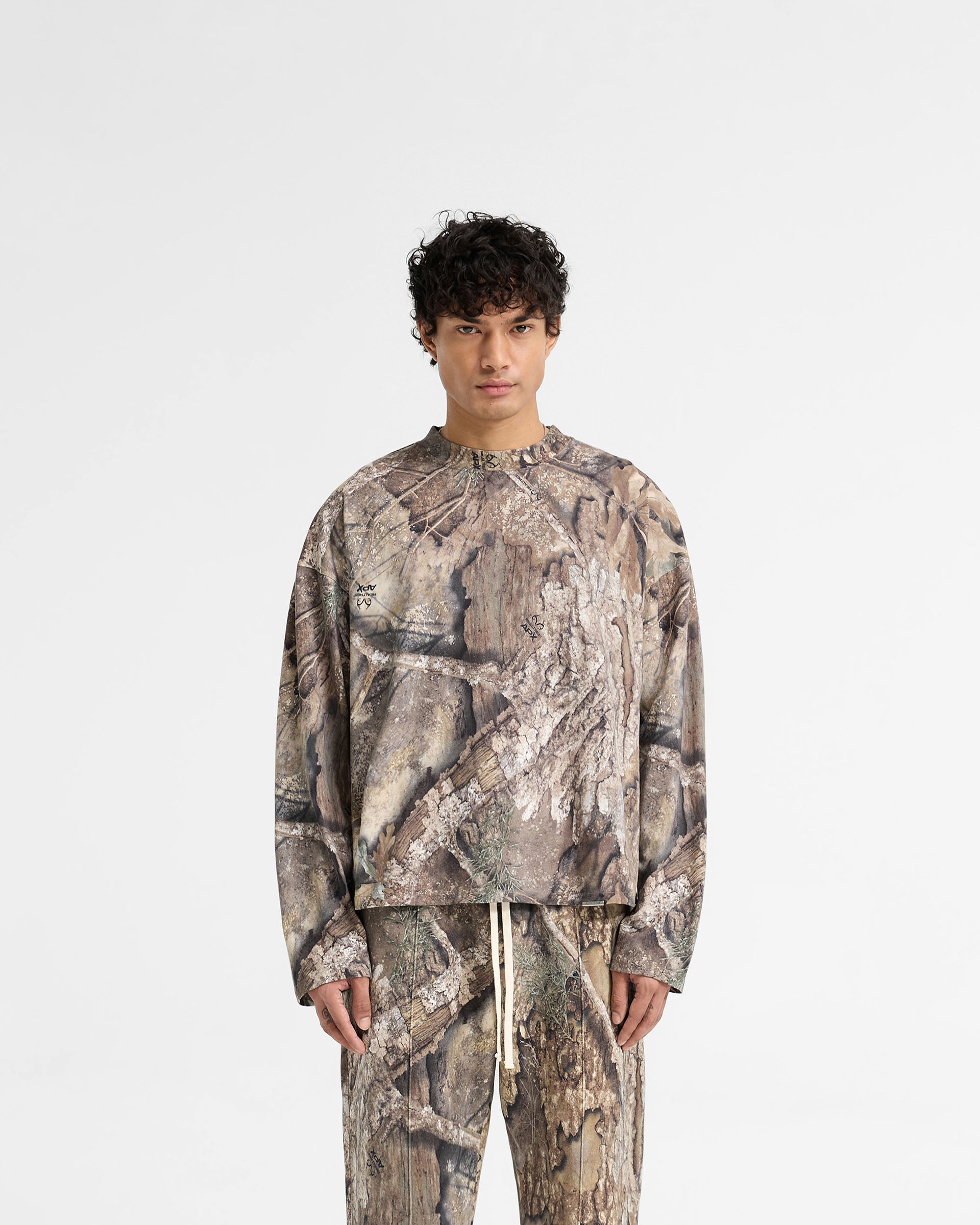 Man wearing a camo long sleeve t-shirt on a plain white background | Realtree Camo Long Sleeve T-Shirt in Camo | Medium weight jersey cotton long sleeve t-shirt | SS25 T-Shirts | Represent Clo