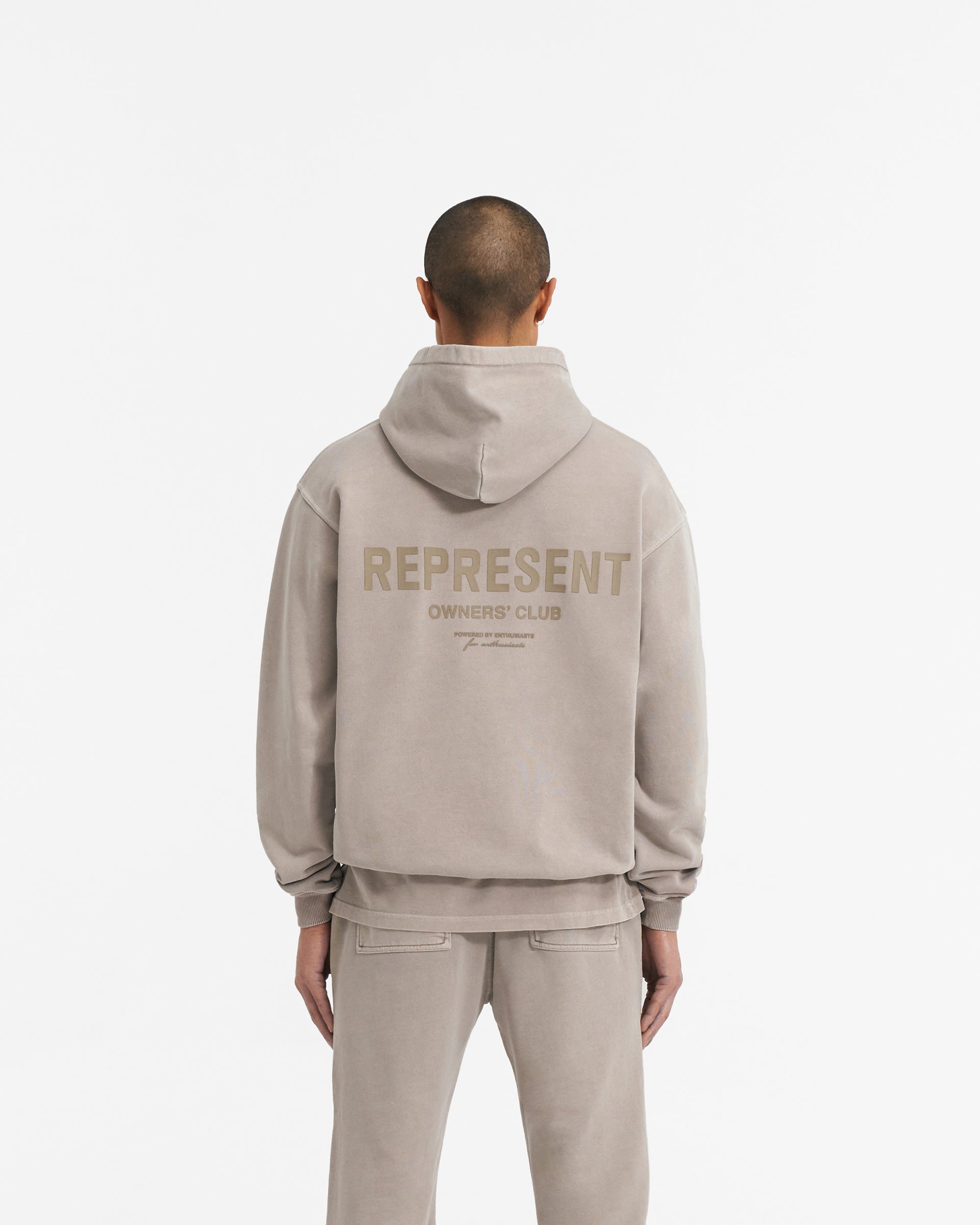 Man wearing a mushroom coloured hoodie on a plain white background | Represent Owners Club Hoodie in Mushroom | Heavy weight oversized fit hoodie with cobrax popper and ribbed trims | Owners Club Hoodies | Represent Clo