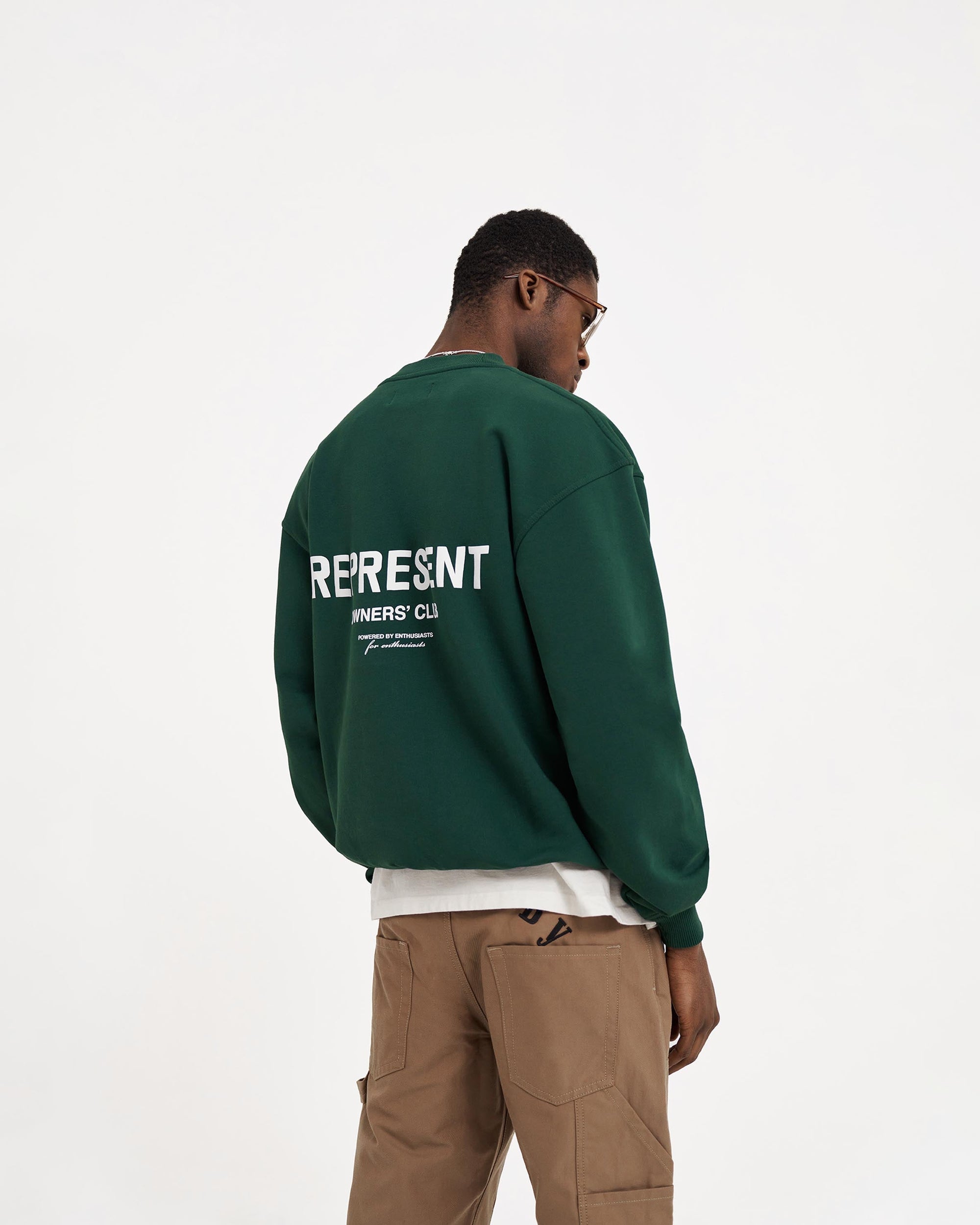 Man wearing a green sweater on a plain white background | Represent Owners Club Sweater in Racing Green | Heavy weight oversized fit crewneck sweater | Owners Club Sweaters | Represent Clo