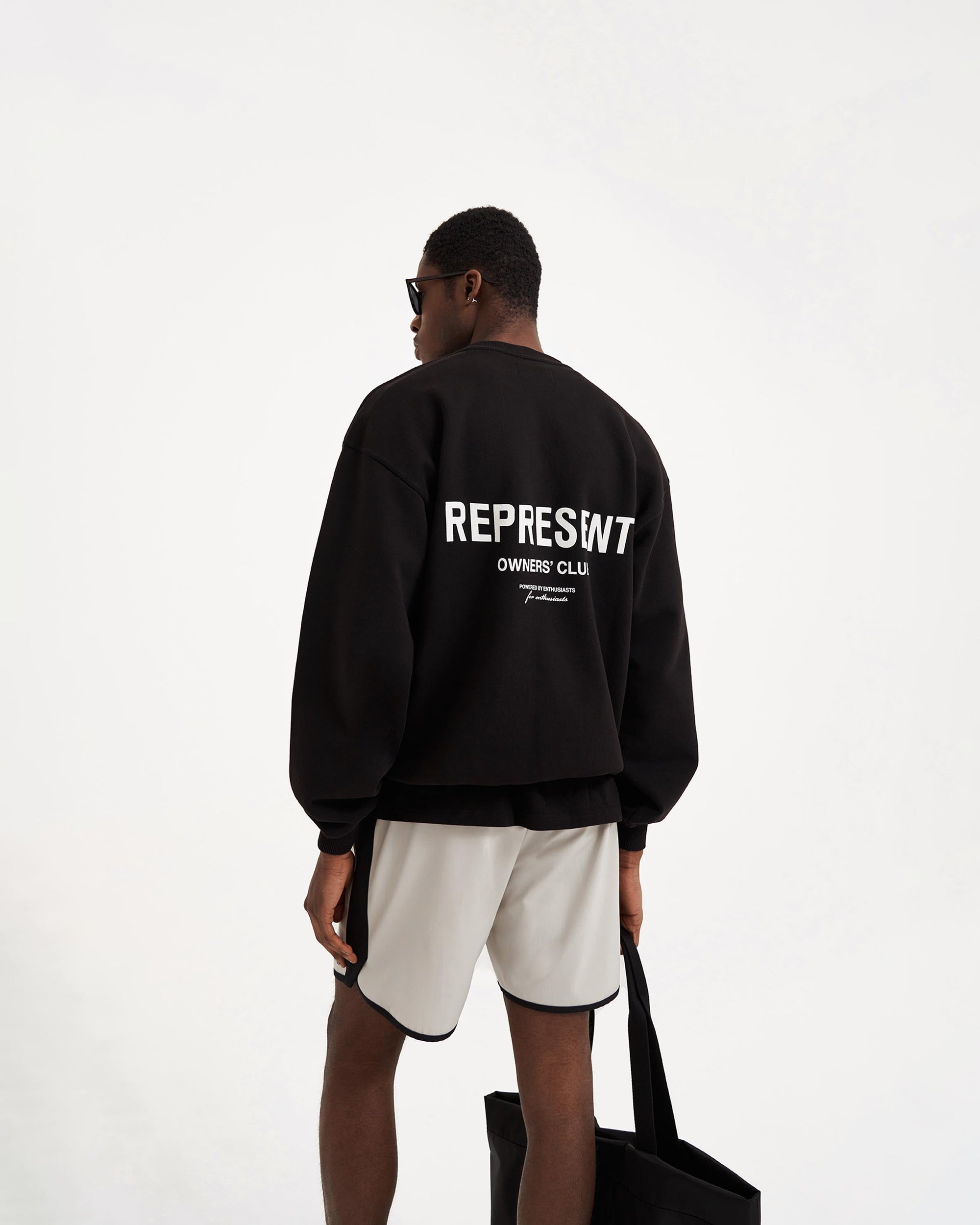 Man wearing a black sweater on a plain white background | Represent Owners Club Sweater in Black | Oversized fit crewneck sweater with ribbed trims | Owners Club Sweaters | Represent Clo