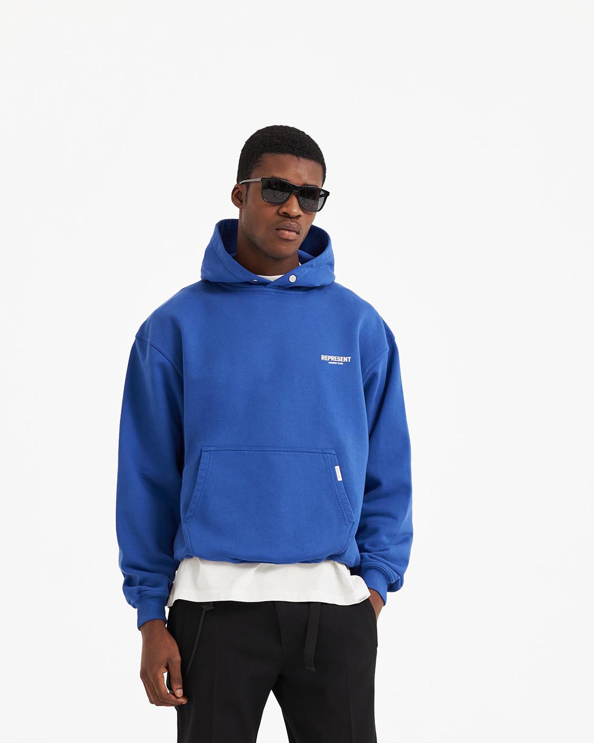 Man wearing an oversized cobalt blue hoodie on a plain white background | Represent Owners Club Hoodie in Cobalt | Heavy weight jersey cotton hoodie | Owners Club Hoodies | Represent Clo