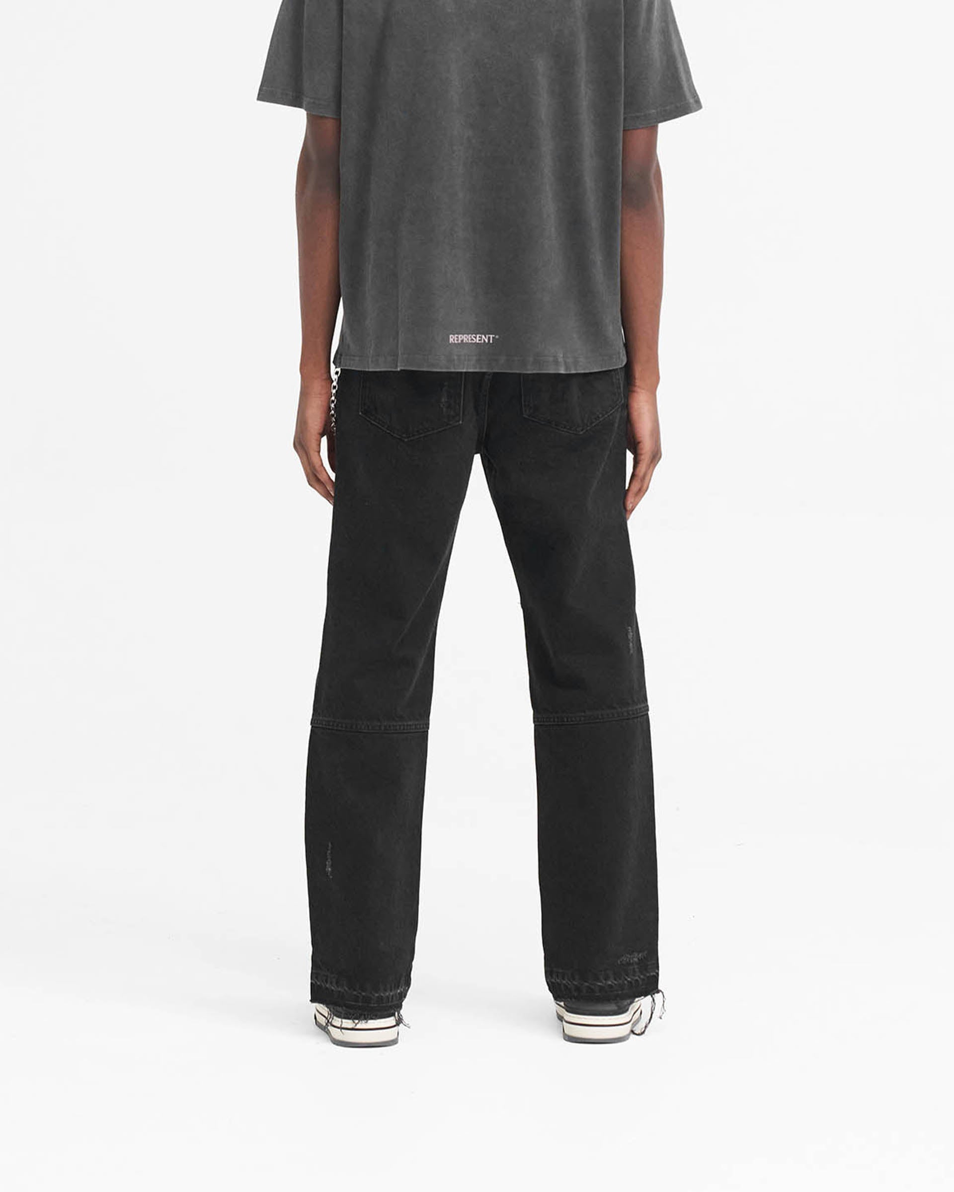 Man wearing off-black denim on a plain white background | R2 Stepped Hem Denim in Off Black | Jeans with straight leg fit and stepped hem | SS24 Denim | Represent Clo