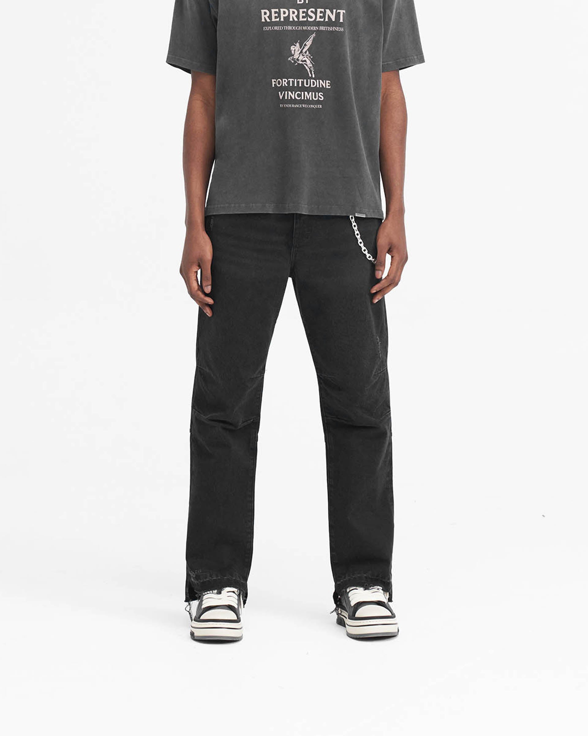 Man wearing off black jeans on a plain white background | R2 Stepped Hem Denim in Off Black | Straight leg jeans with stepped hem | SS24 Denim | Represent Clo