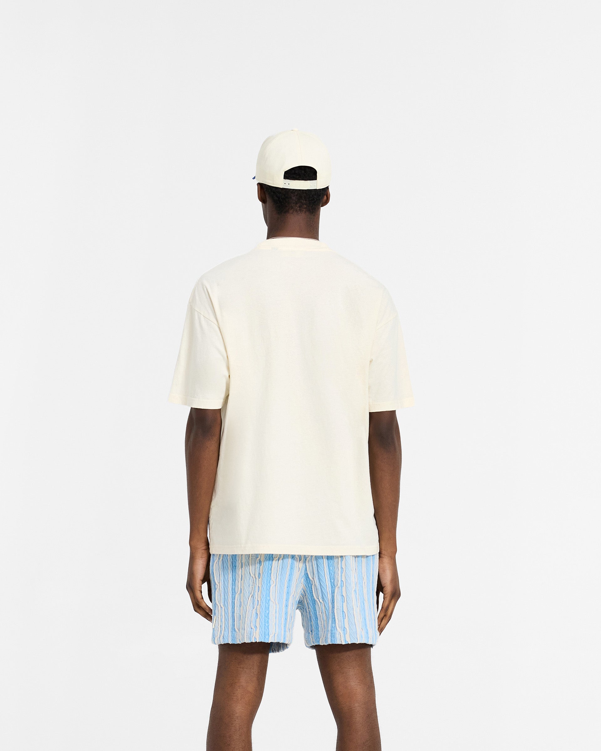 Man wearing an antique white t-shirt on a plain white background | Permanent Vacation Pocket T-Shirt in Antique White | Slub fabric t-shirt with chest pocket | SC24 T-Shirts | Represent Clo