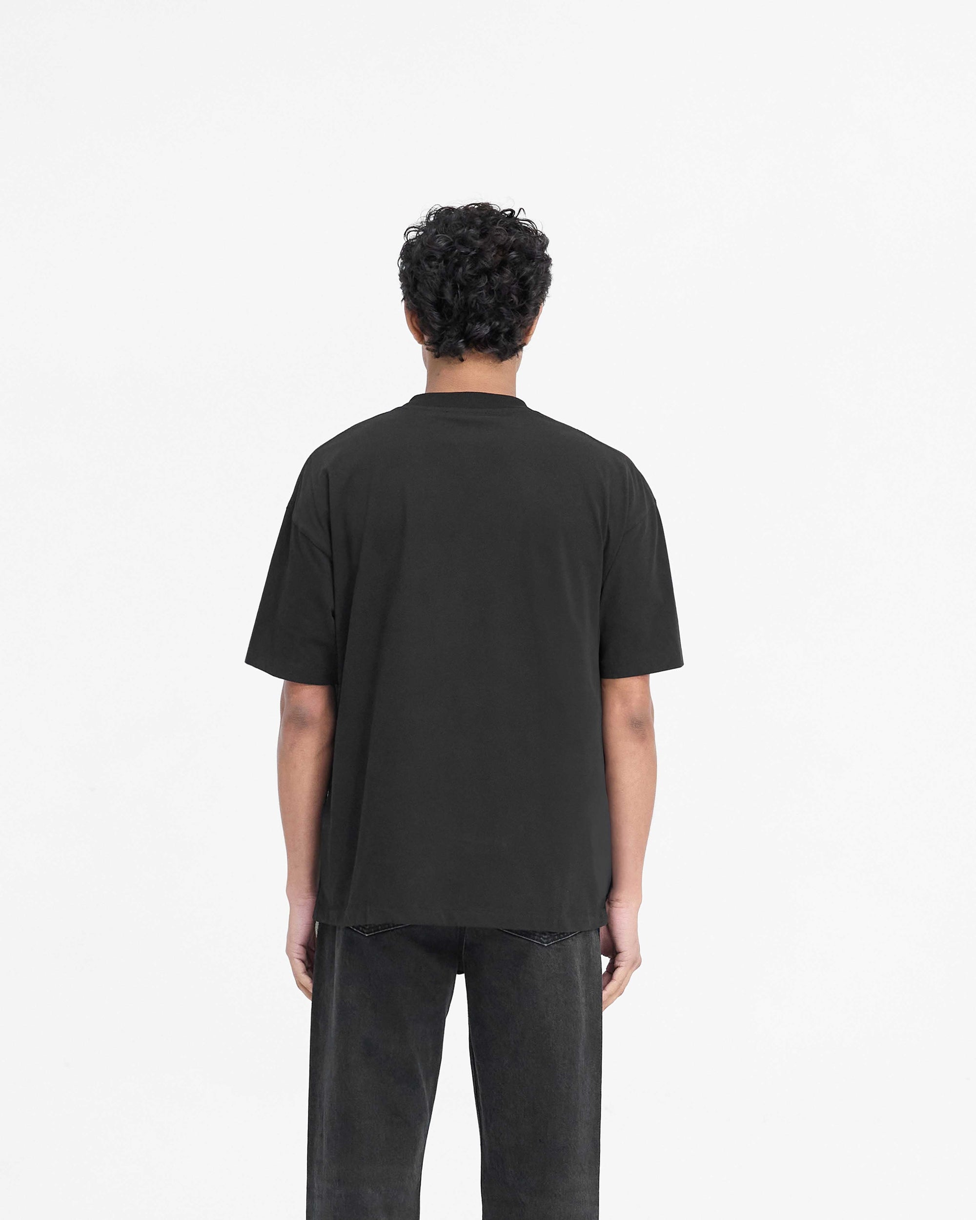 Man wearing a black t-shirt on a plain white background | Block Logo T Shirt in Jet Black | Slightly oversized t-shirt with metal branding | PRE SS25 T-Shirts | Represent Clo