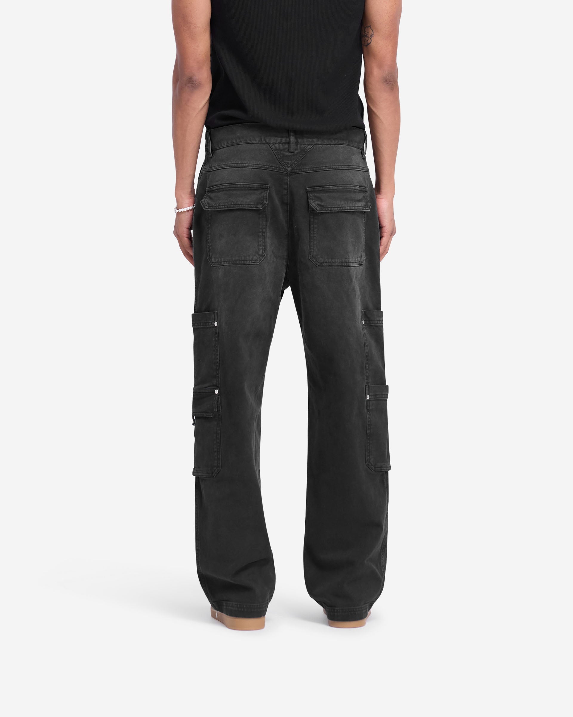 Man wearing washed black pants on a plain white background | Workshop Pant in Washed Black | Relaxed straight fit pants with 3D cargo pockets | FW24 Pants | Represent Clo