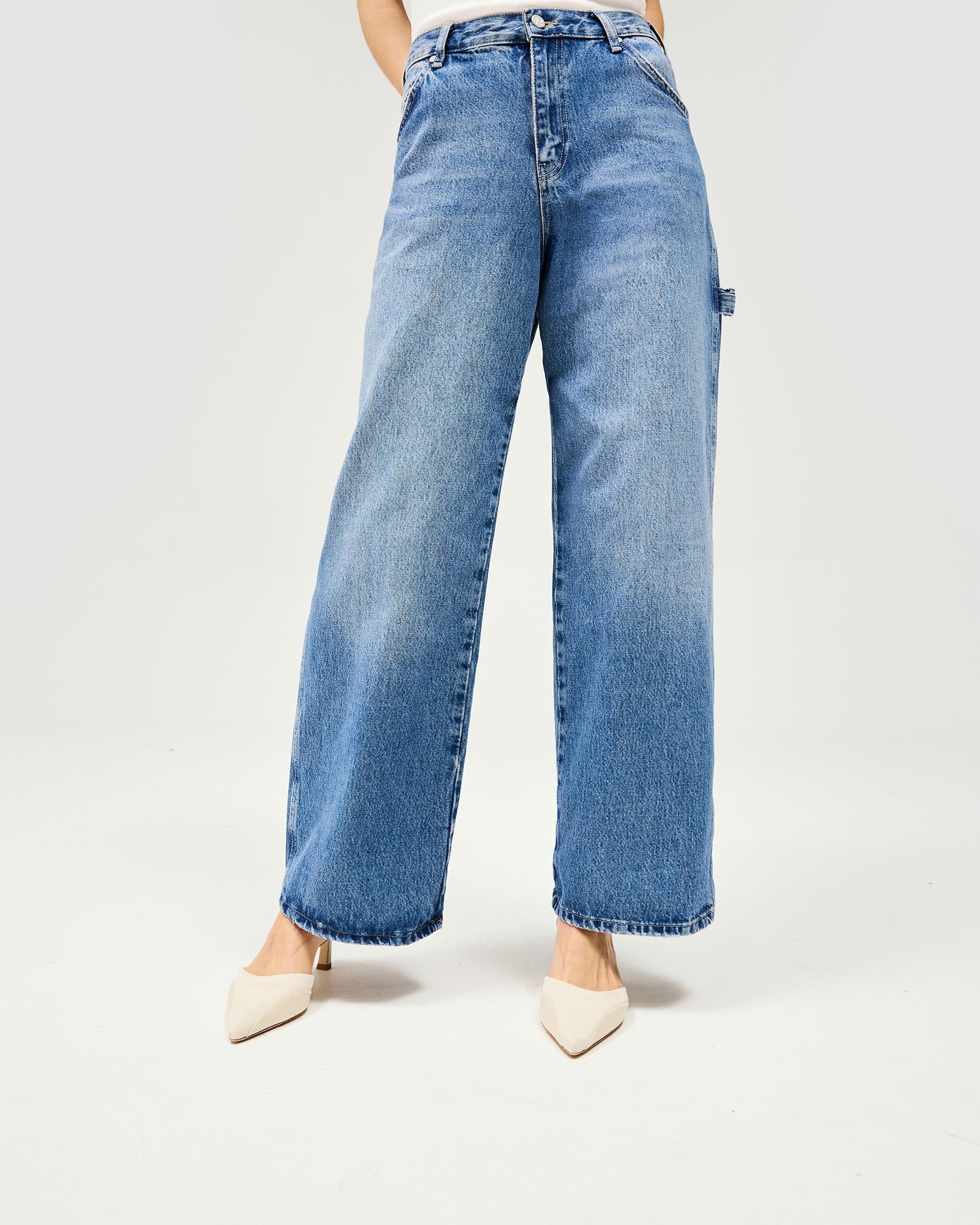 Woman wearing oversized blue jeans on a plain white background | Skater Jean in Washed Blue | Oversized low rise jeans with skater pockets | Womens SS25 Jeans | Represent Clo