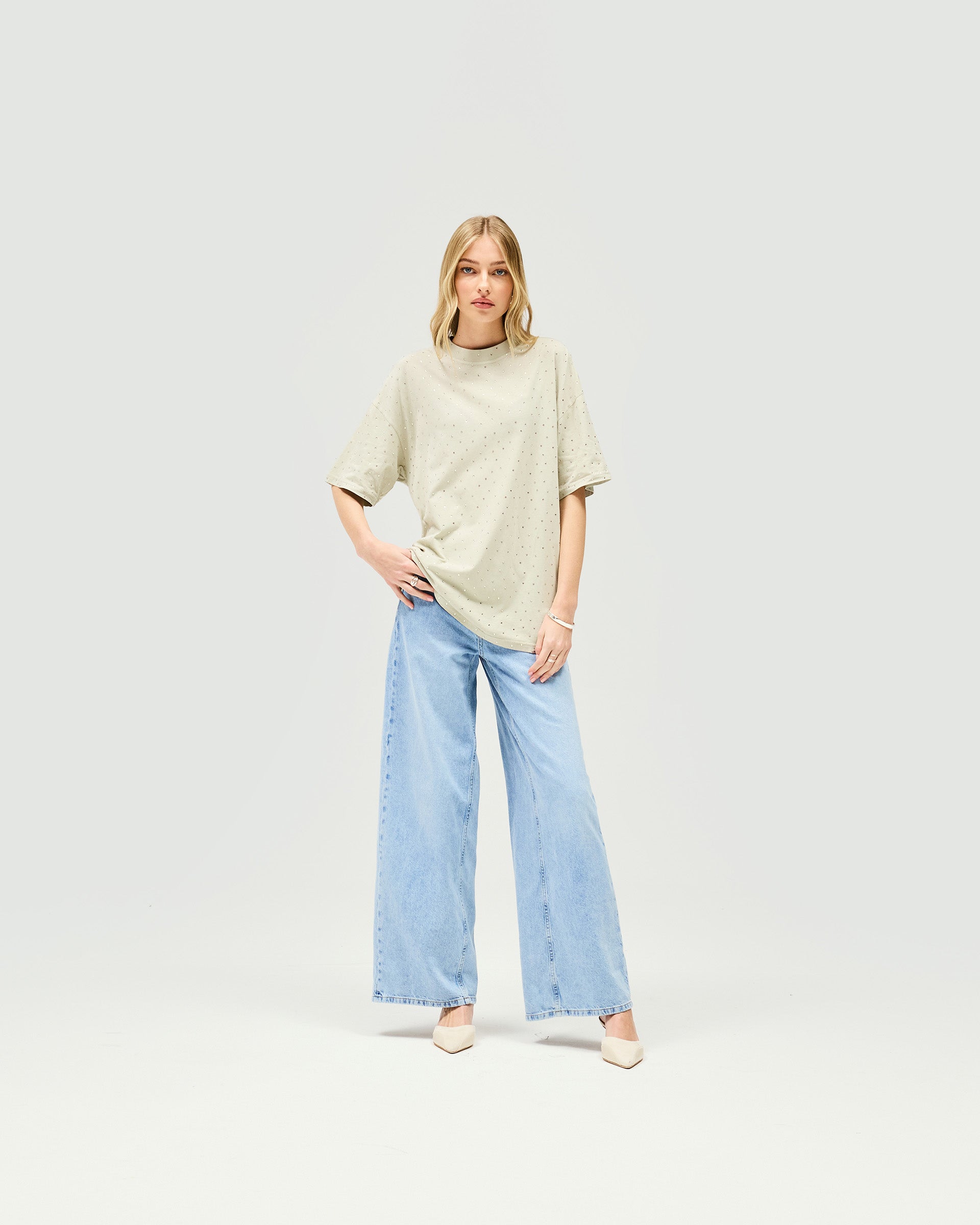 Woman wearing an oversized grey t-shirt on a plain white background | Spark T-Shirt in Storm | Soft acid wash oversized t-shirt with hot fix detail | Womens SS25 Tops | Represent Clo