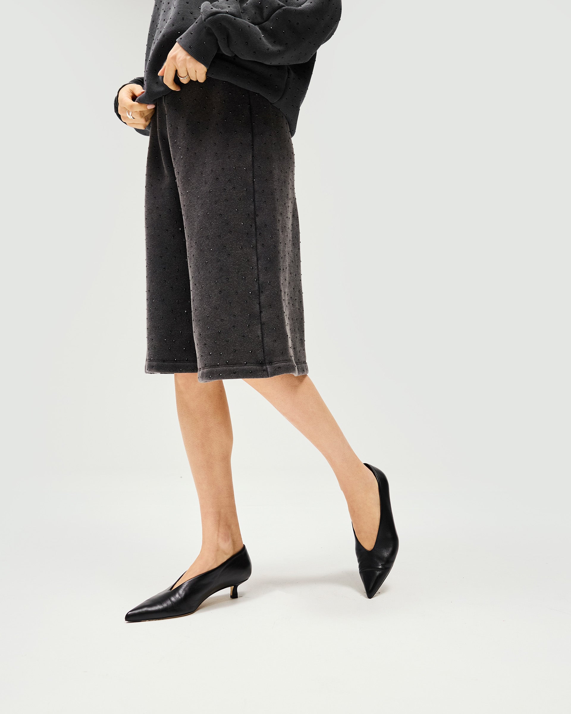 Woman wearing washed grey leather shorts on a plain white background | Spark Shorts in Washed Grey | Leather Bermuda shorts with elasticated waist | Womens SS25 Shorts | Represent Clo