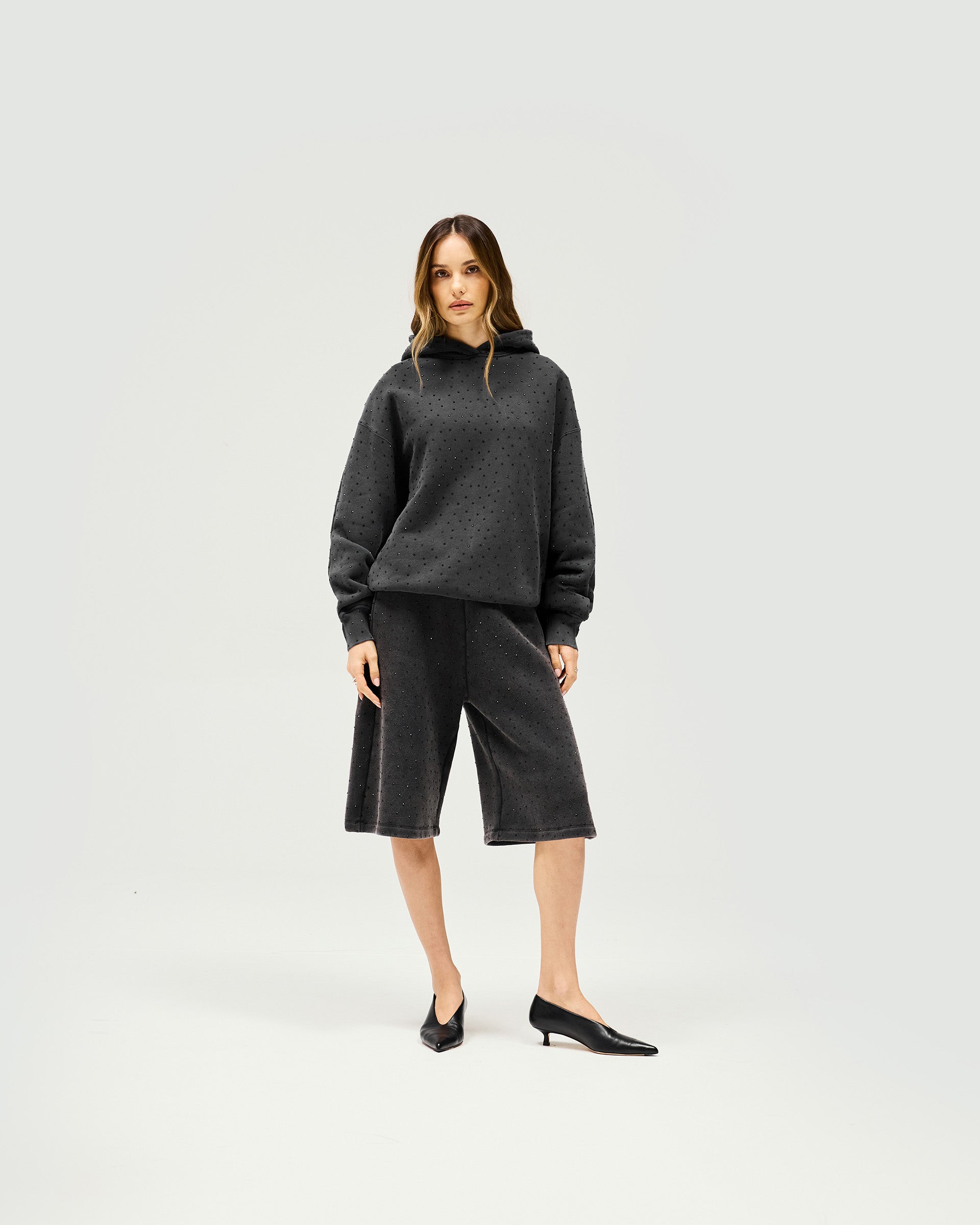 Woman wearing grey leather Bermuda shorts on a plain white background | Spark Shorts in Washed Grey | Leather shorts with elasticated waist | Womens SS25 Shorts | Represent Clo