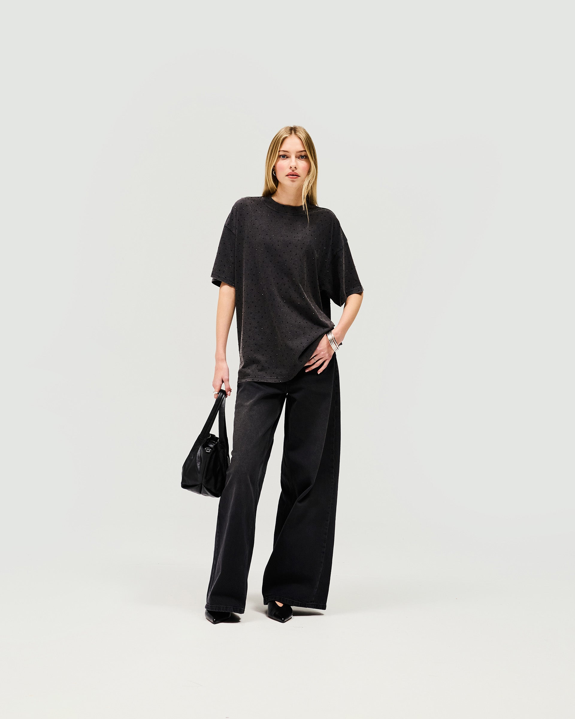 Woman wearing an oversized grey t-shirt on a plain white background | Spark T-Shirt in Washed Grey | Oversized t-shirt with soft acid wash and hot fix detail | Womens SS25 Tops | Represent Clo