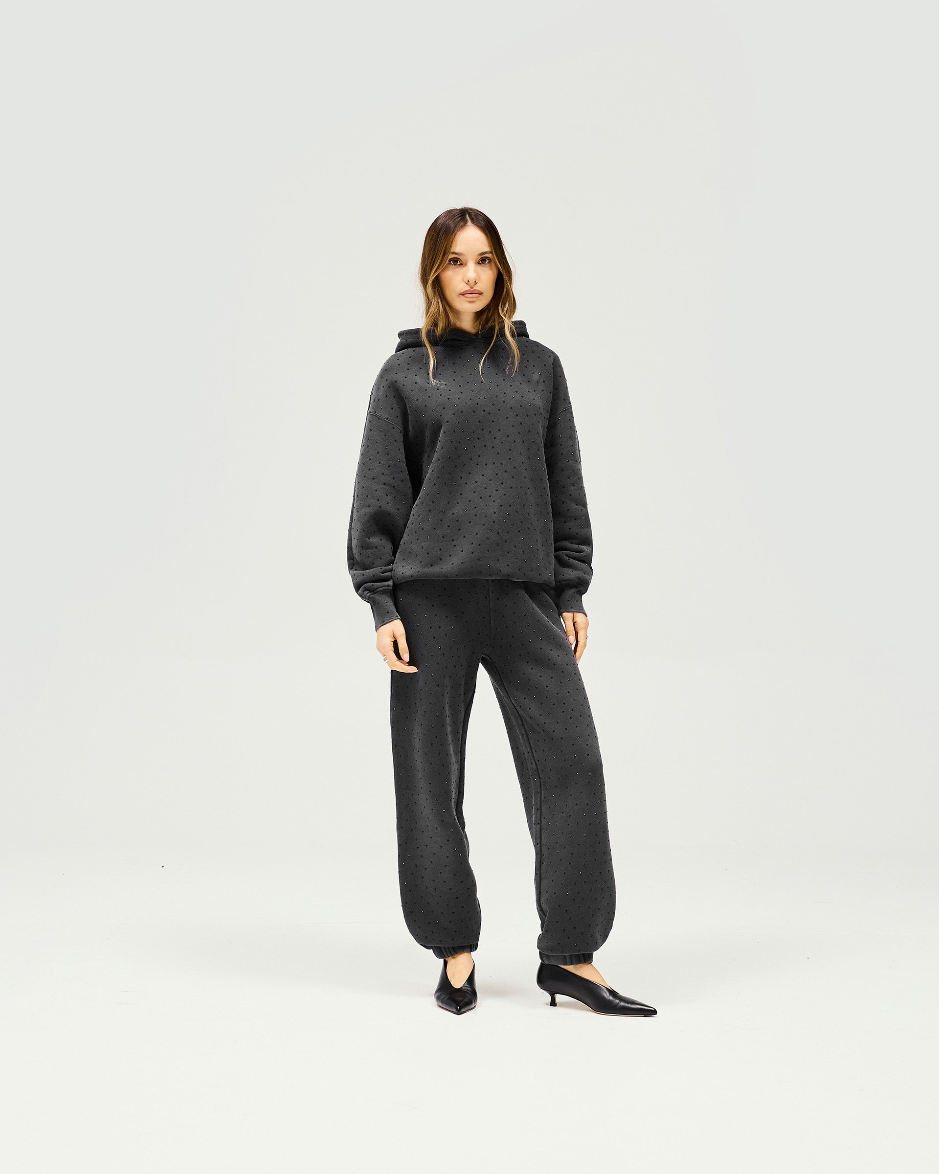 Woman wearing grey trackpant on a plain white background | Spark Trackpant in Washed Grey | Heavy hotfix jogger style with relaxed fit | Womens SS25 Bottoms | Represent Clo