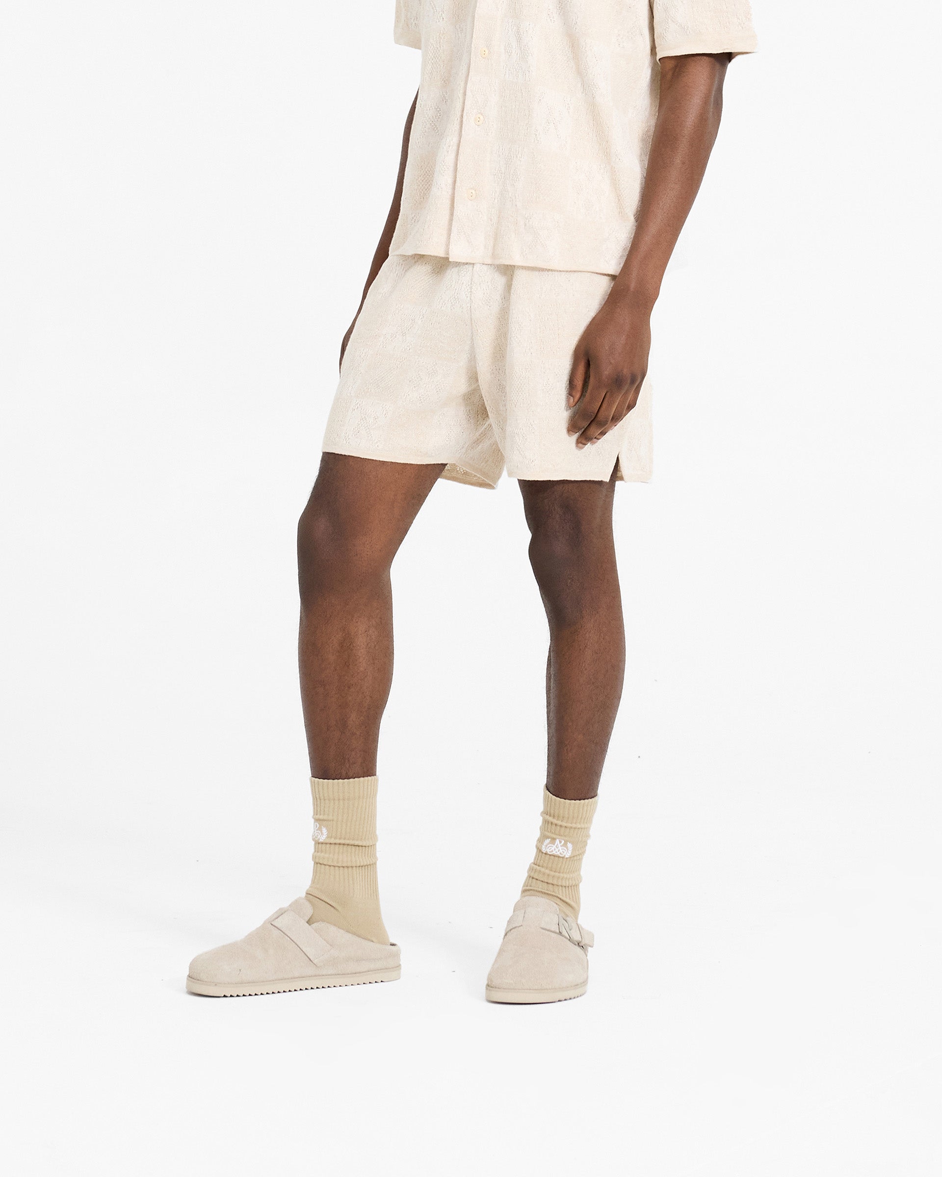 Back product image of mens cream shorts on a plain white background | Crochet Short in Cream | Relaxed shorts with checkerboard intarsia pattern | SC24 Shorts | Represent Clo