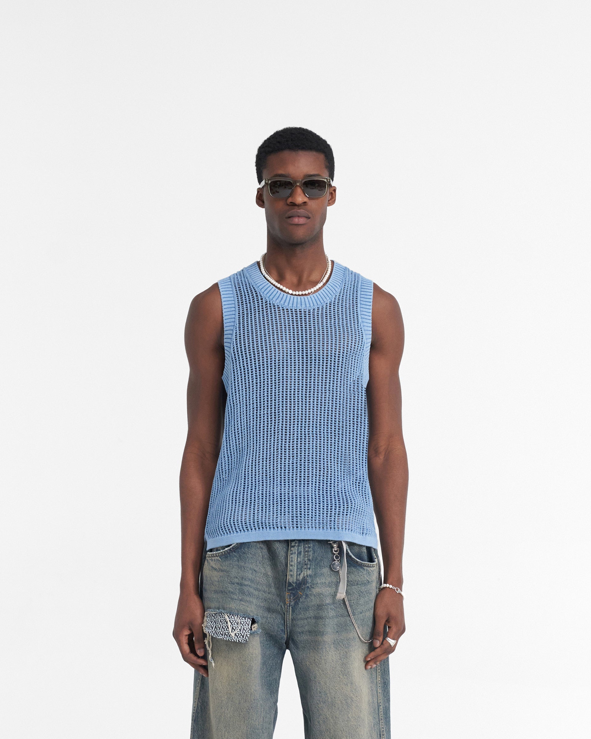 Man wearing a blue knitted vest on a plain white background | Washed Knit Vest in Sky Blue | Regular fit knitwear vest with ribbed neckline | SS24 Knitwear | Represent Clo