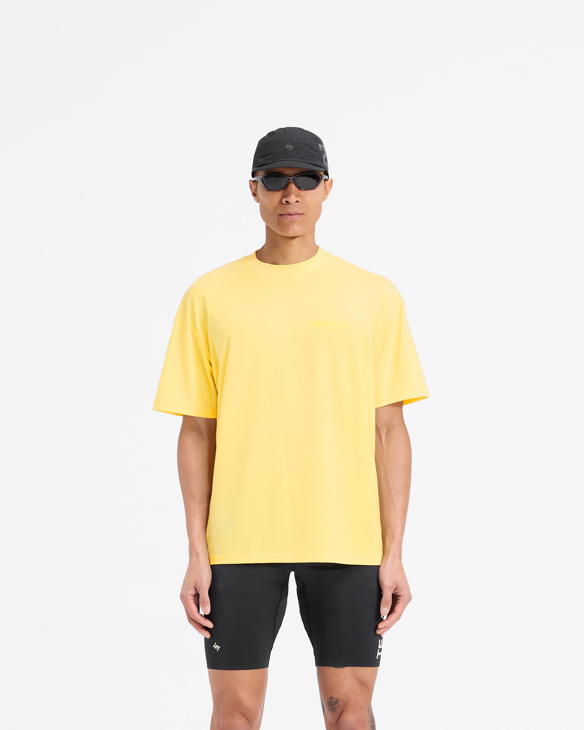 Man wearing a yellow oversized t-shirt on a plain white background | Team 247 Oversized T-Shirt in Lemon | Training t-shirt with quick drying lightweight construction | 247 T-Shirts | Represent Clo