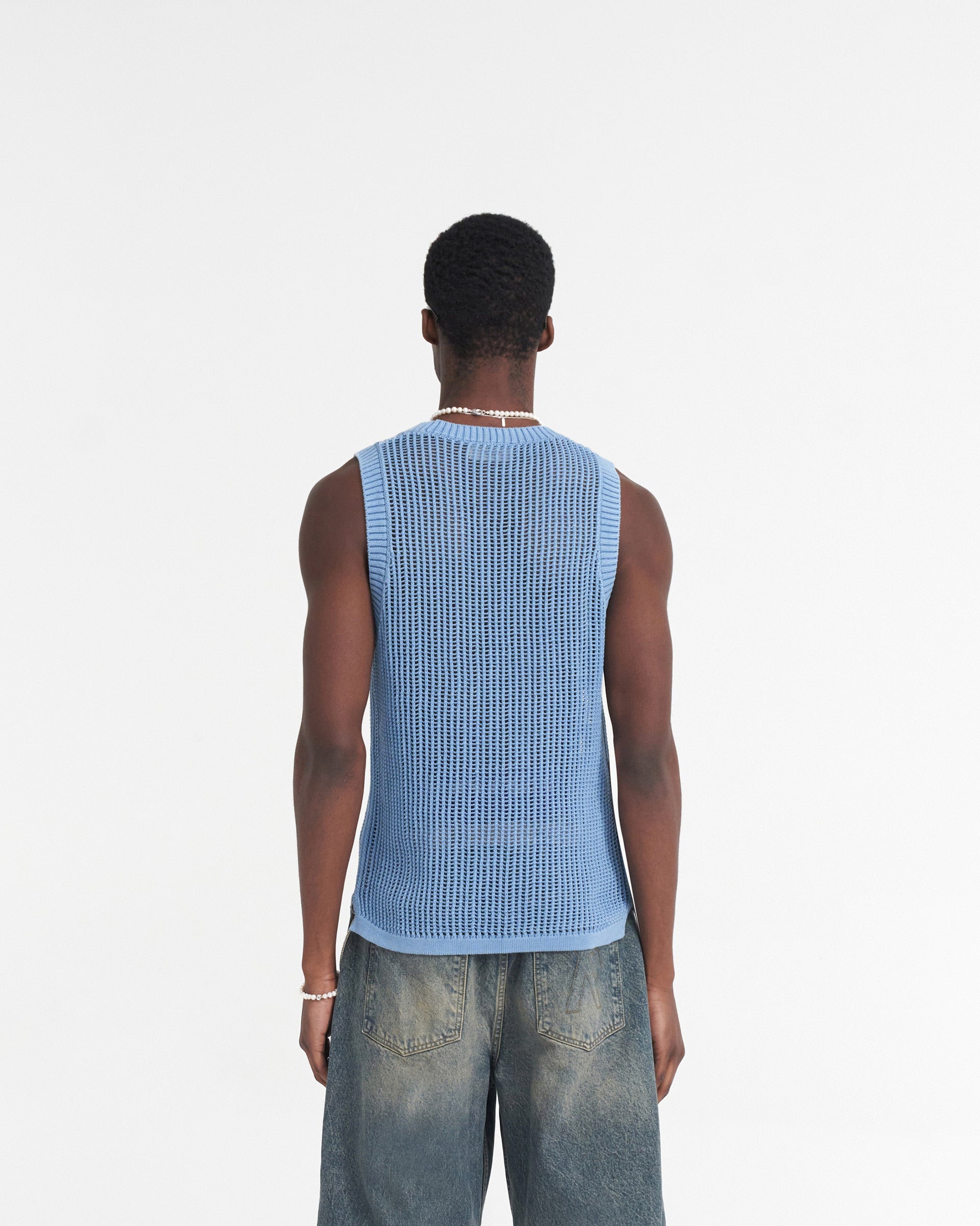Man wearing a blue knit vest on a plain white background | Washed Knit Vest in Sky Blue | Regular fit knitted vest with ribbed neckline | SS24 Knitwear | Represent Clo
