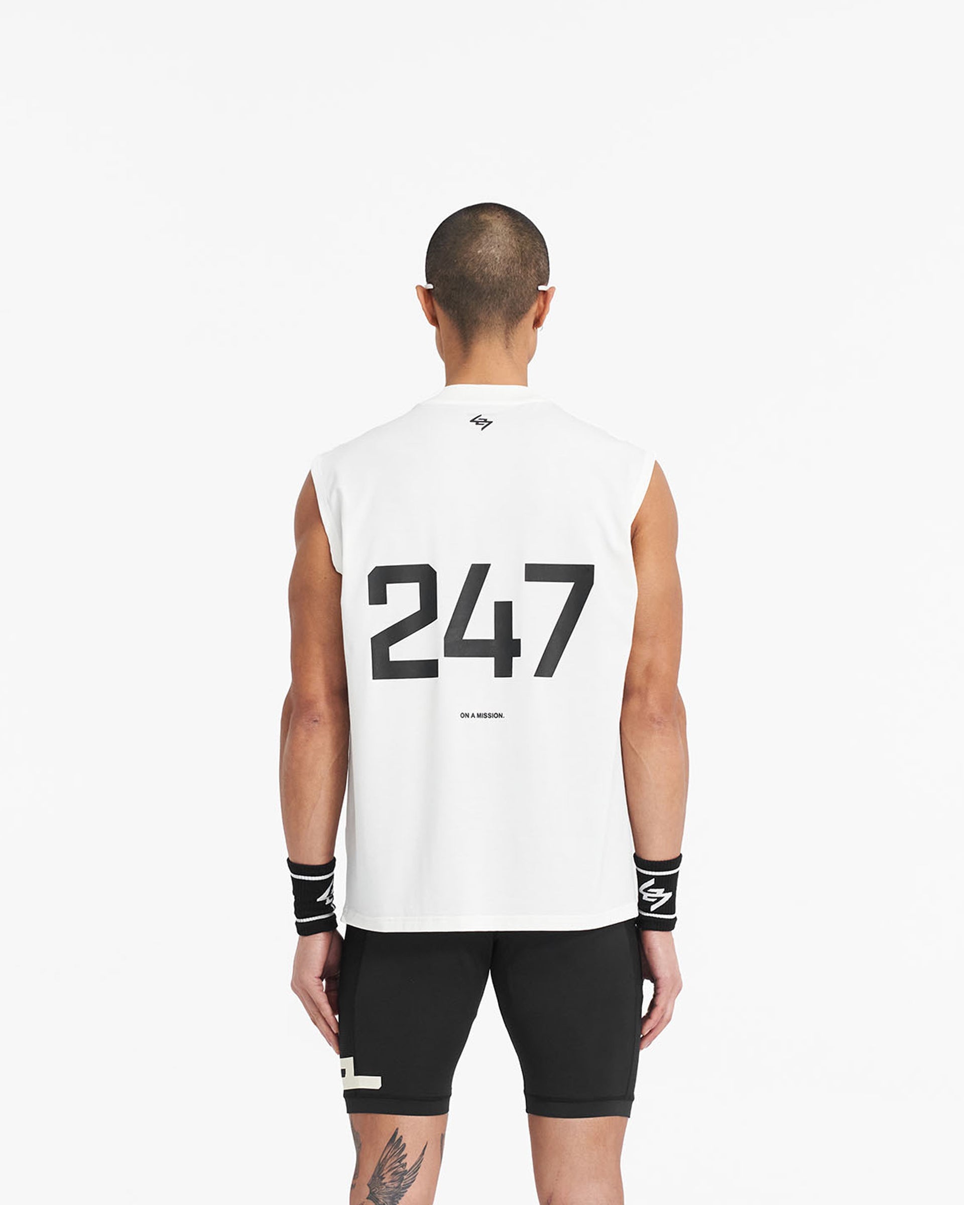 Man wearing an oversized white tank top on a plain white background | 247 Oversized Tank in Flat White | Lightweight and breathable tank with 4-way stretch | 247 T-Shirts | Represent Clo