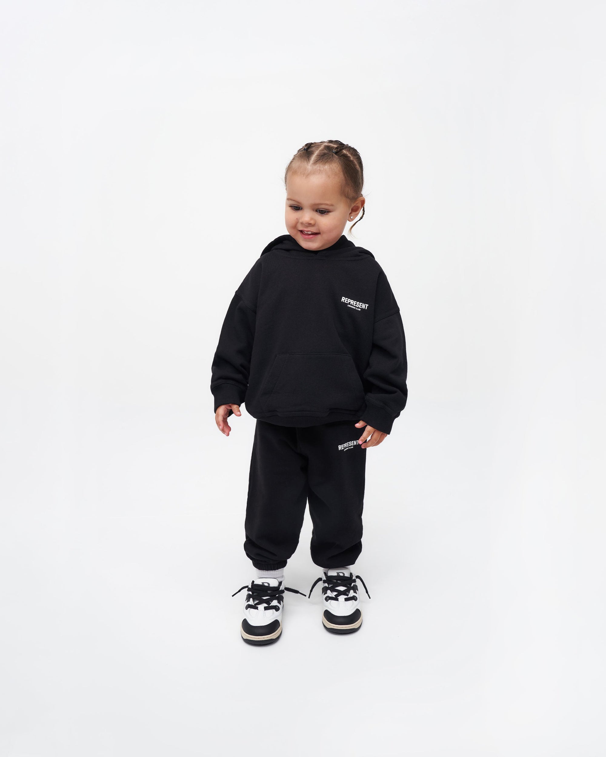 Back product image of a kids black sweatpants on a plain white background | Represent Mini Owners Club Sweatpants in Black | Kids joggers with elasticated waistband and cuffs | Owners Club Pants | Represent Clo